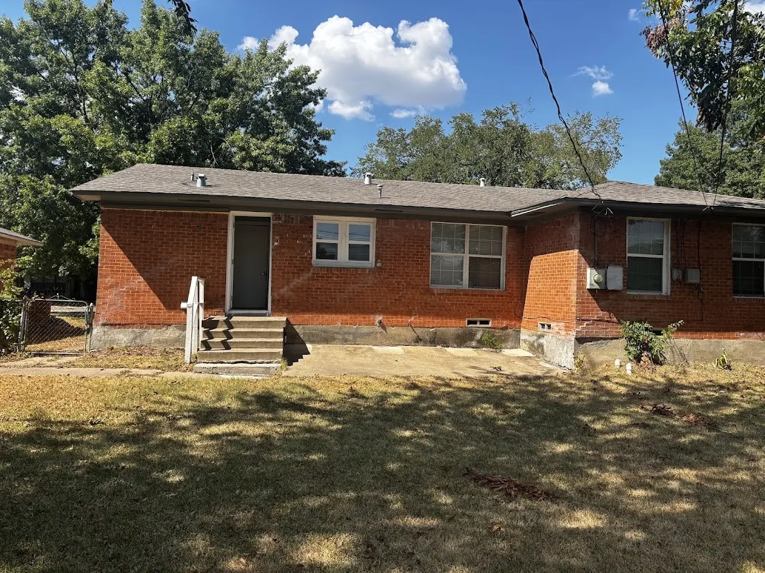 Brick exterior with multiple windows and a private entry