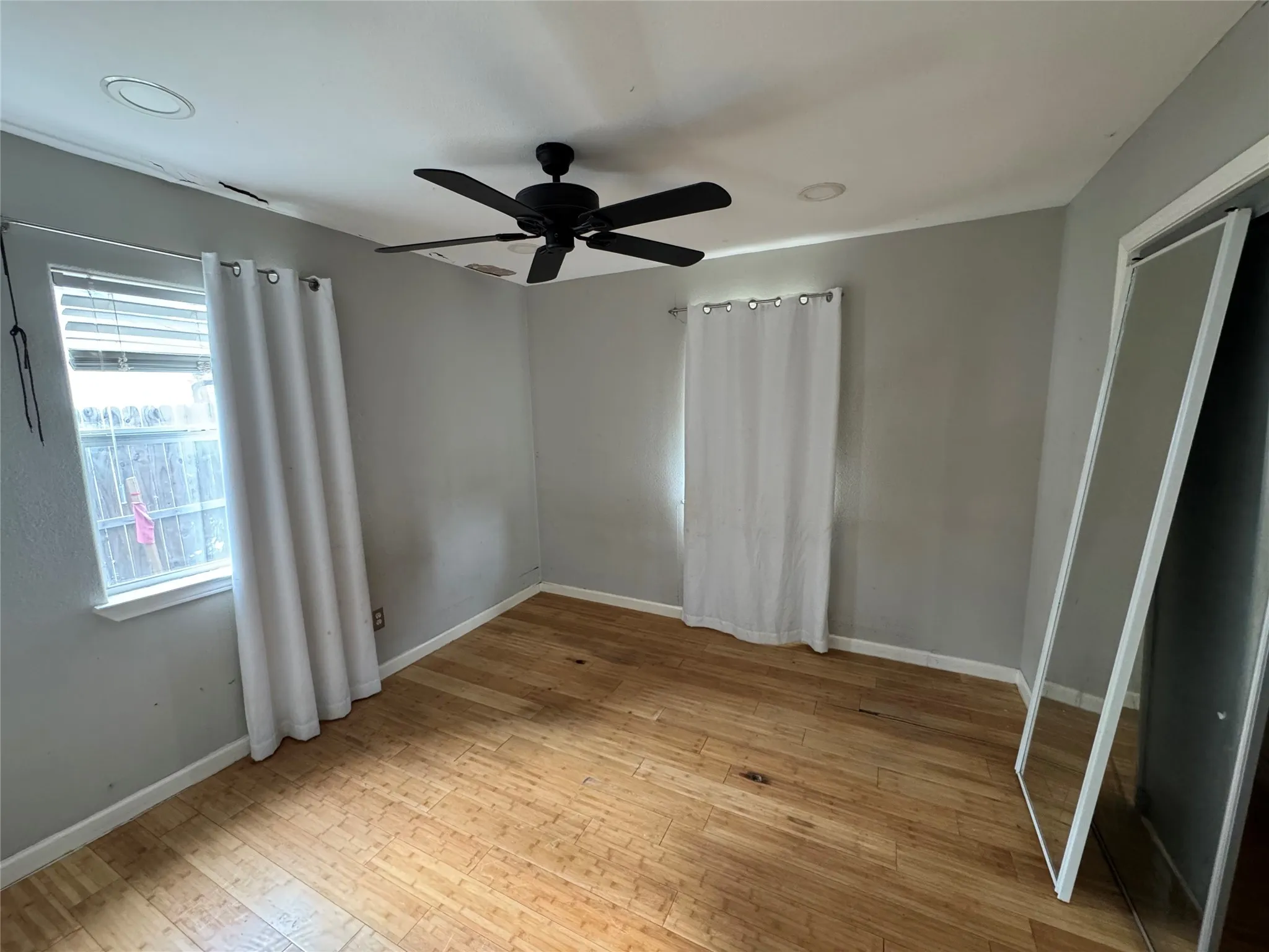 Hardwood flooring throughout, featuring a ceiling fan with integrated lighting and recessed lighting
