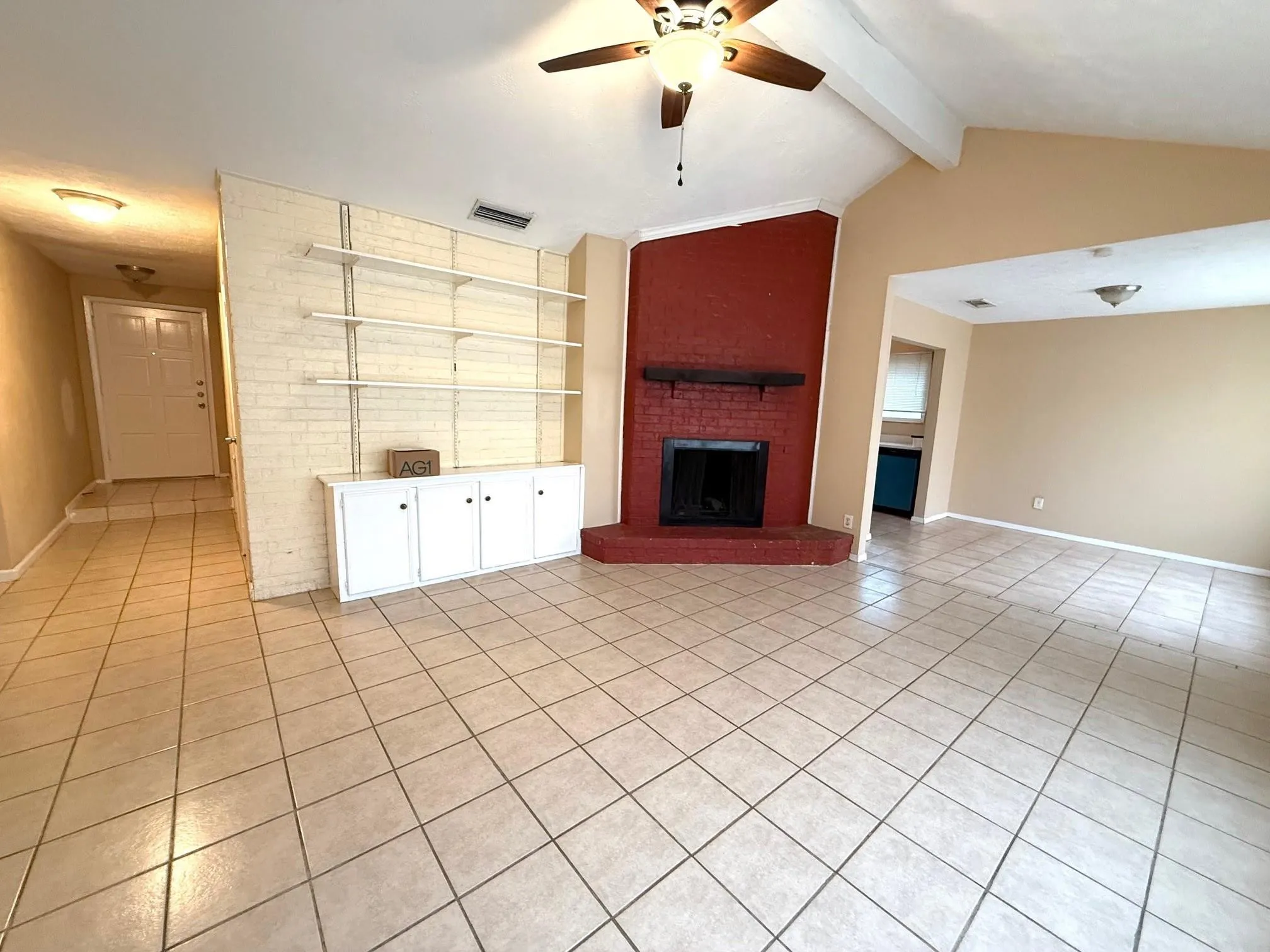 Vaulted ceiling with exposed beams, ceiling fan, and tiled flooring