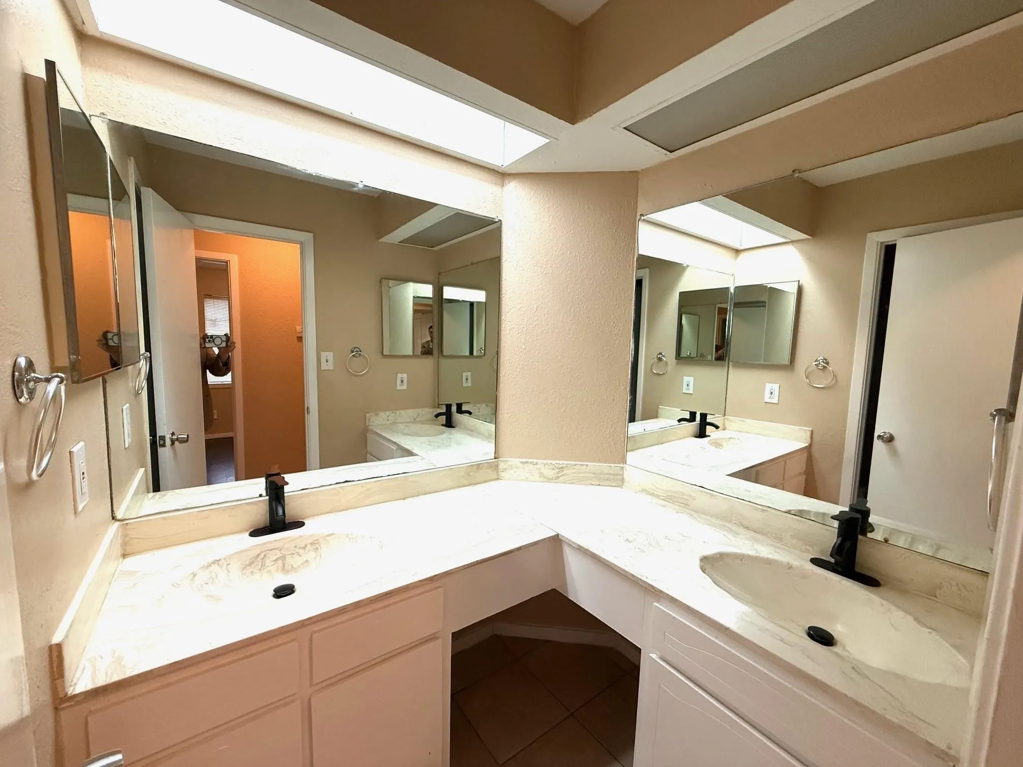 Dual basin vanity with integrated sinks, expansive counter space, and wall-mounted mirrors