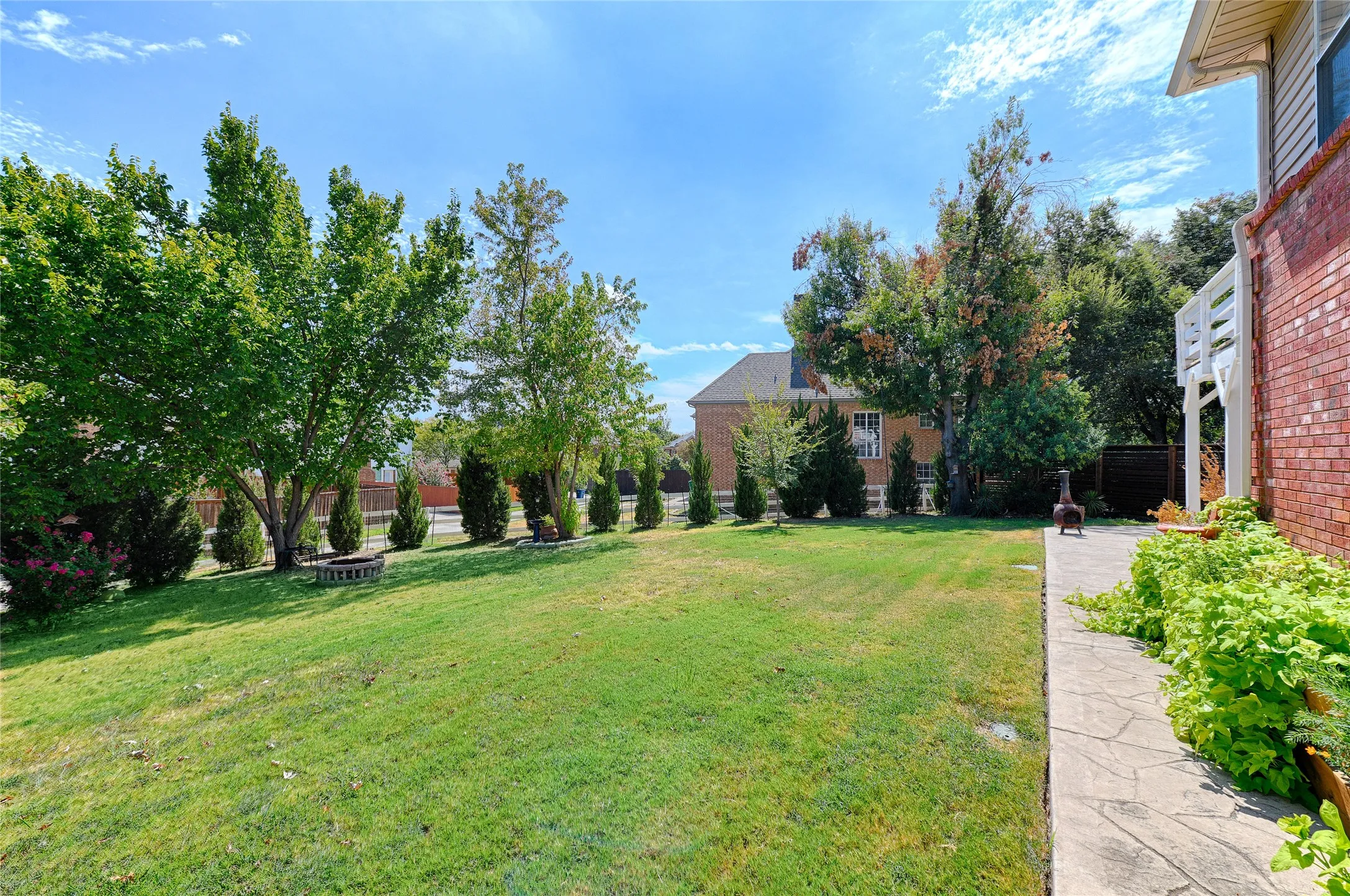Expansive lawn with mature trees and established landscaping