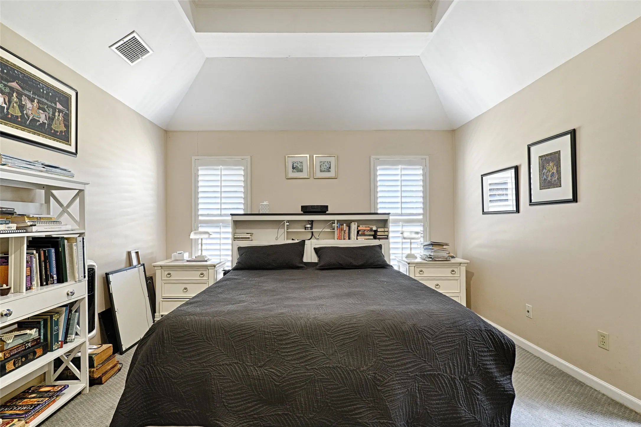 Vaulted ceiling, two windows with plantation shutters, wall-to-wall carpeting, and neutral wall tones