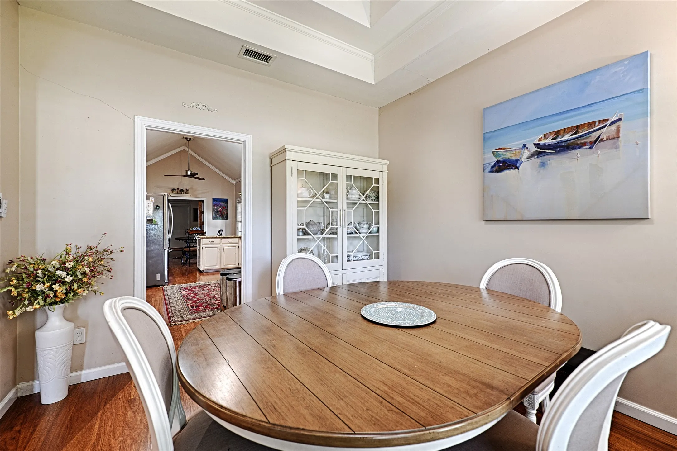 Tray ceiling, wood-finish flooring, white built-in display cabinet, and recessed lighting