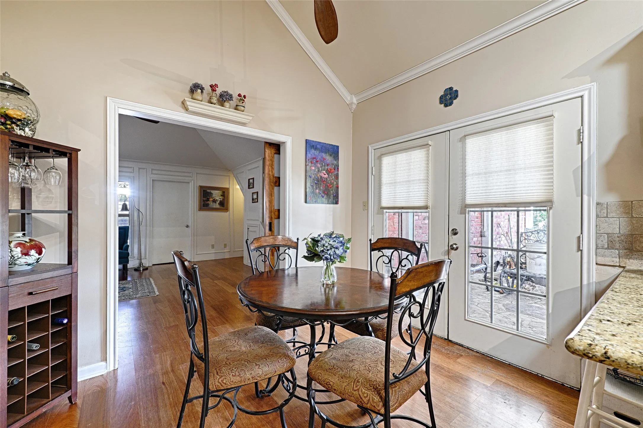 Hardwood flooring throughout, vaulted ceiling, and dual glass-paned doors