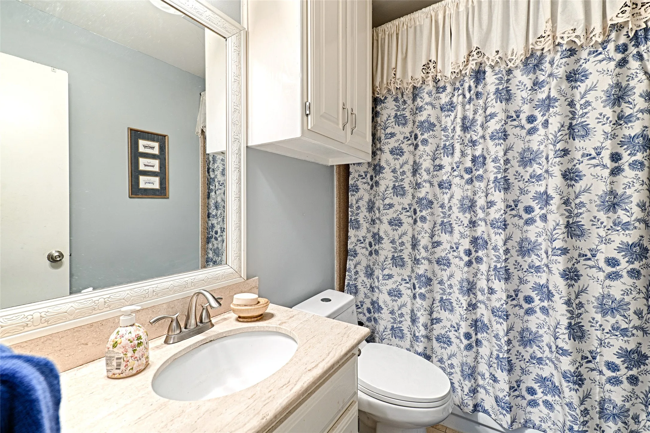 Vanity with an integrated oval sink, brushed nickel faucet, and a large framed mirror