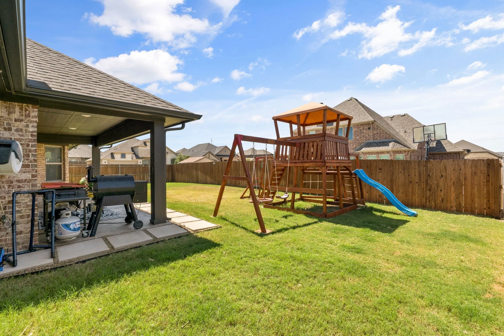 Covered patio with recessed lighting, brick exterior, and a privacy fence