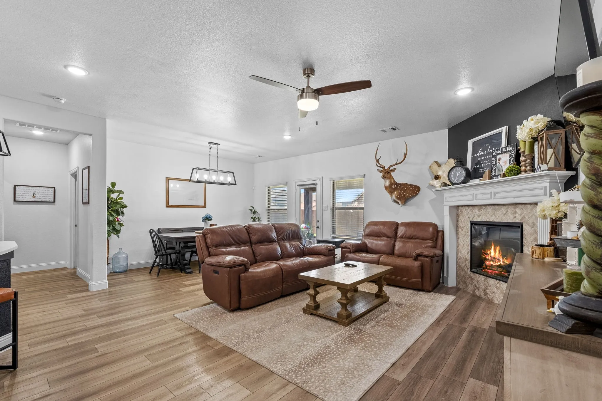 Wood-finish flooring throughout, recessed ceiling lighting, and a ceiling fan with integrated light