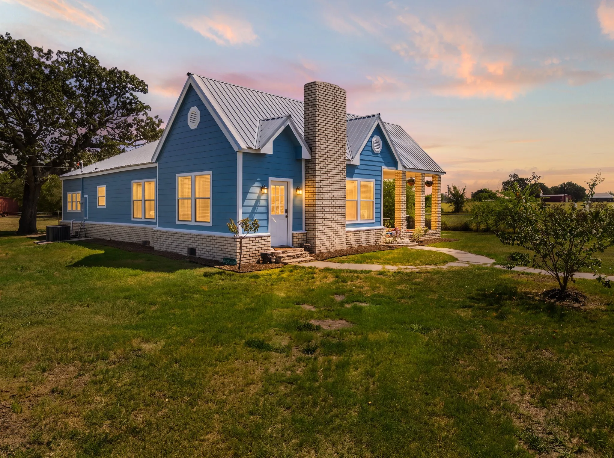 Blue-sided residence with white trim and a metal roof