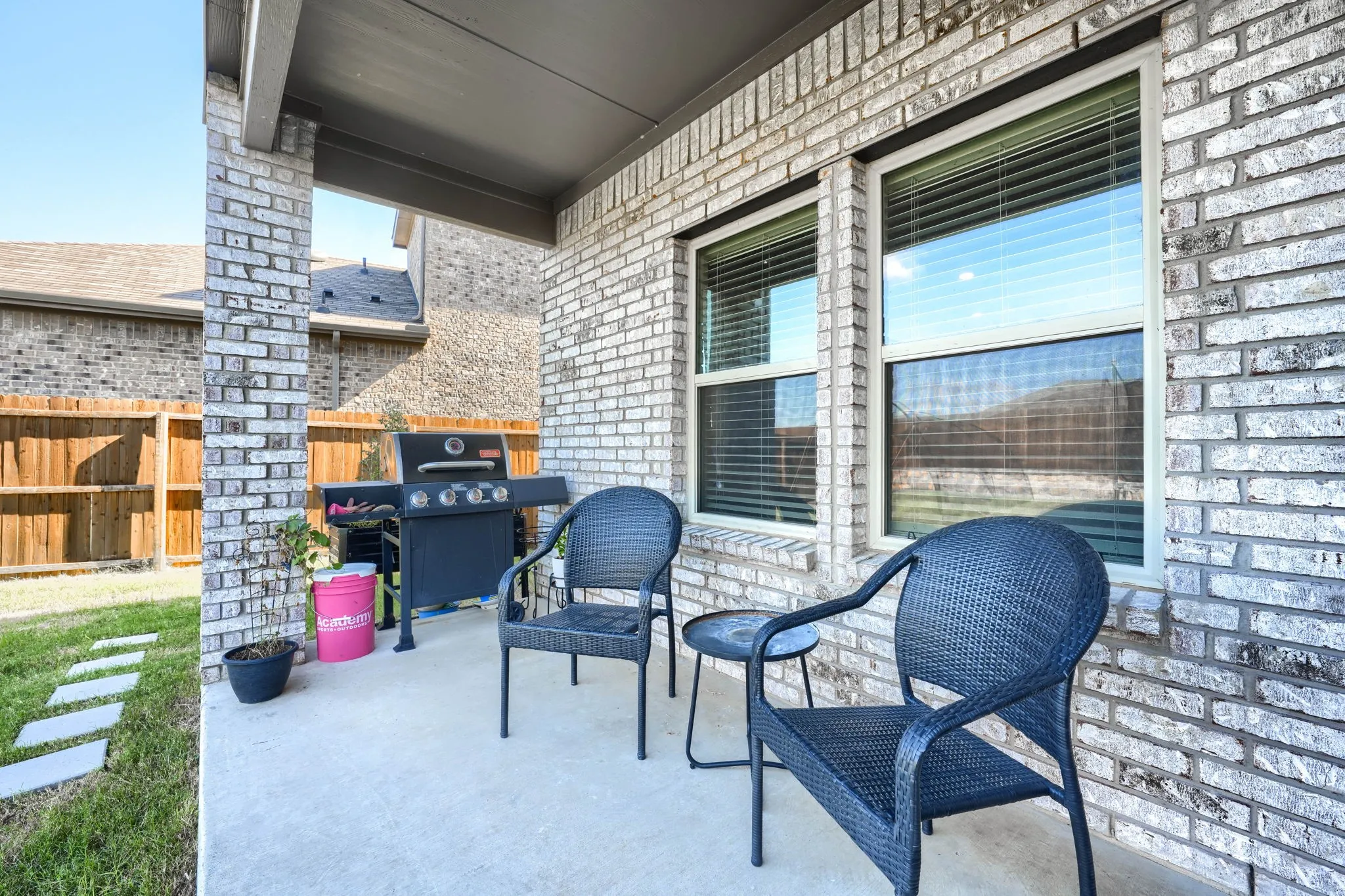 Covered patio featuring a concrete slab and a light-colored brick exterior