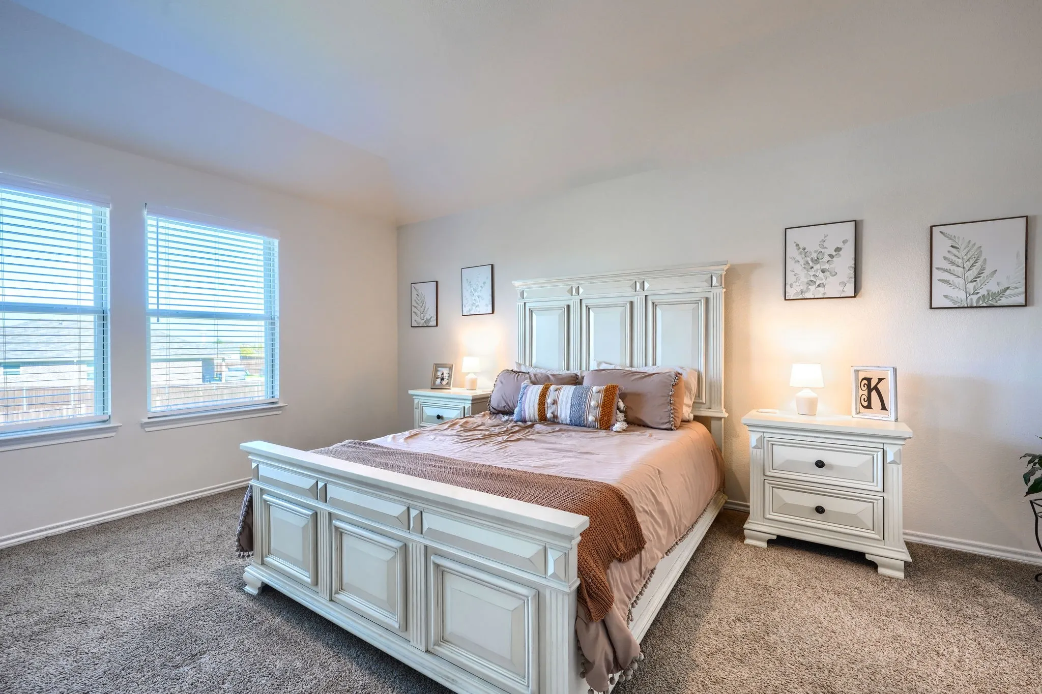 Carpeted flooring, two windows with blinds, and white walls