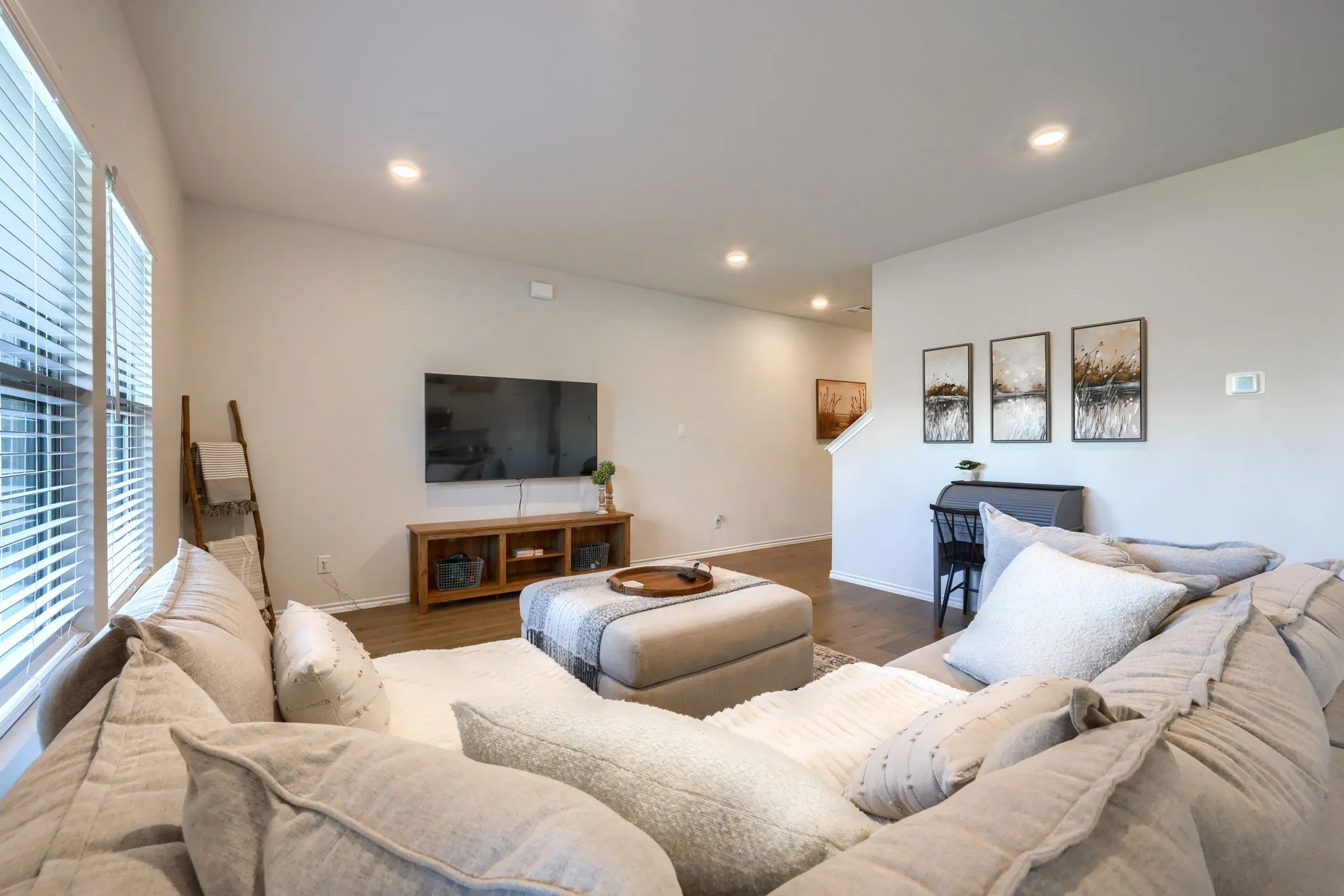Spacious living area featuring high ceilings, recessed lighting, and wood-finish flooring