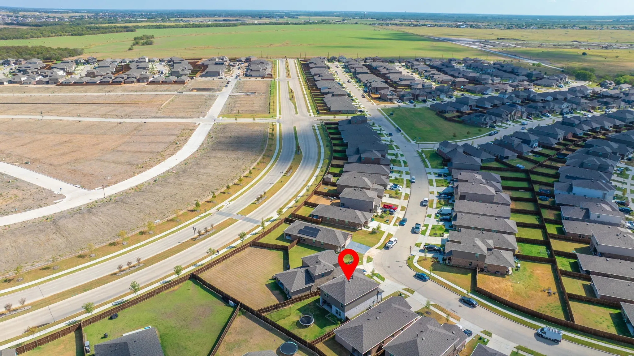 Aerial perspective of a developed residential community with surrounding green spaces