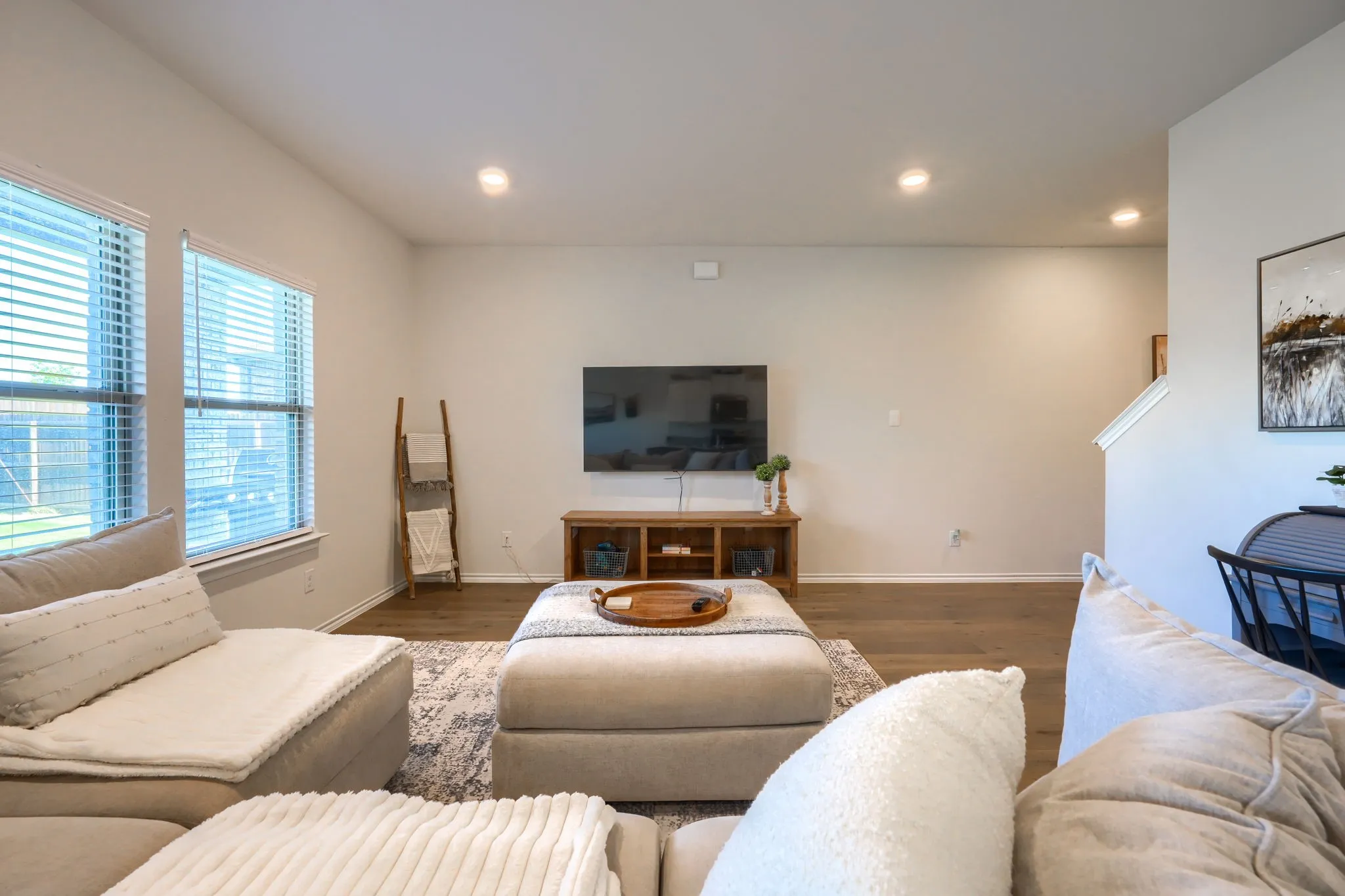 Recessed lighting, wood-finish flooring, two windows with blinds, and light-toned wall paint