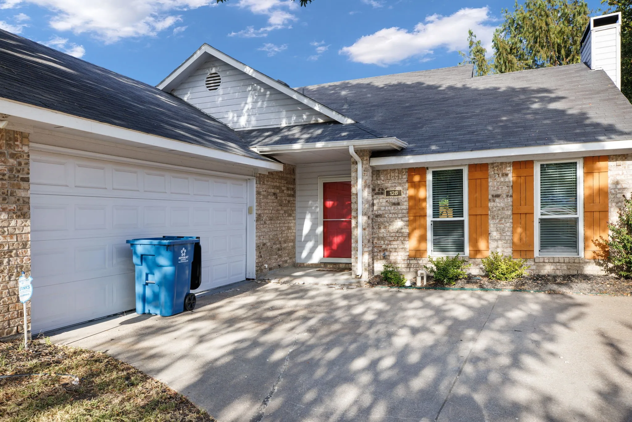 Brick and siding exterior with a dark shingle roof