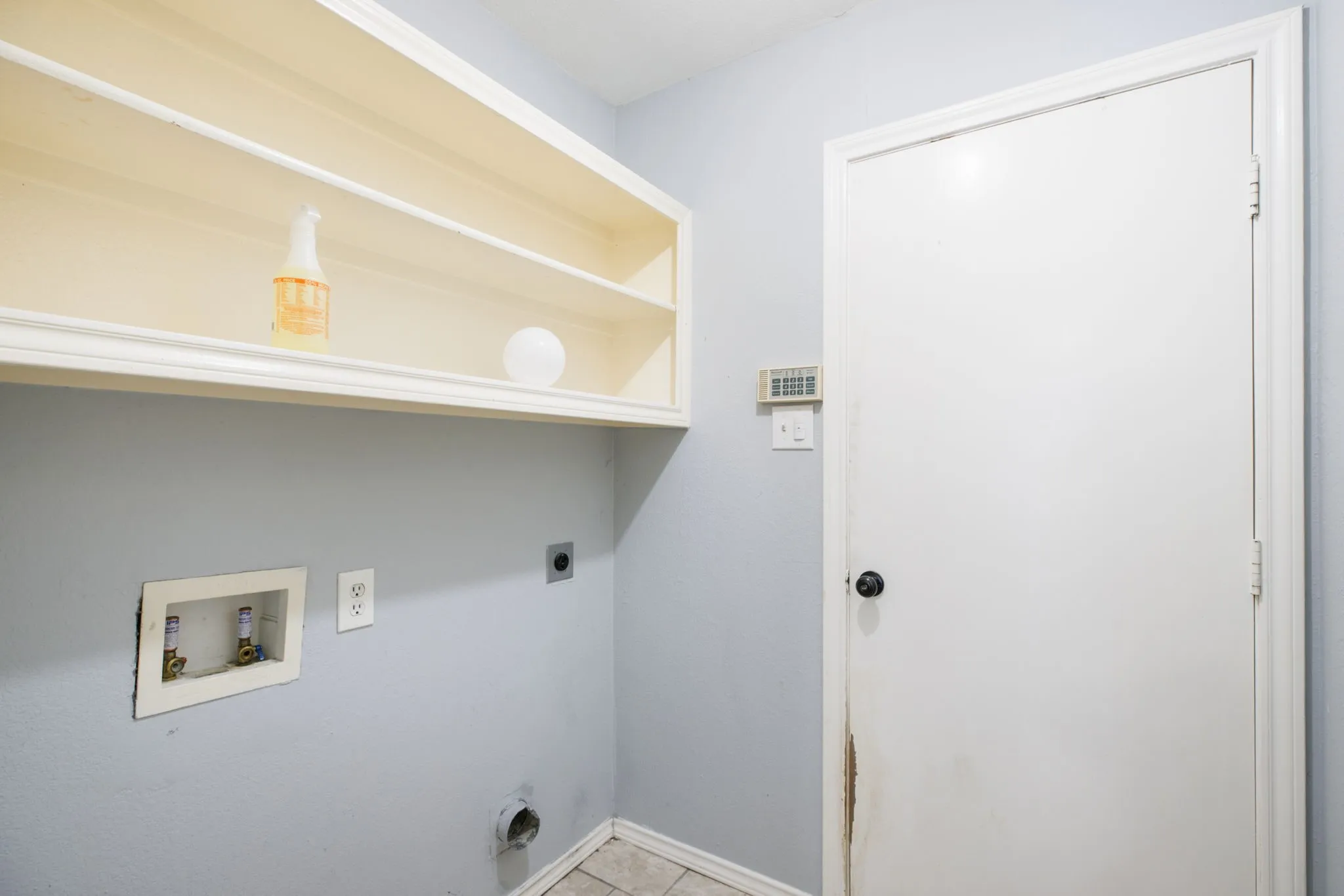 Laundry area featuring built-in shelving, tile flooring, and utility hookups
