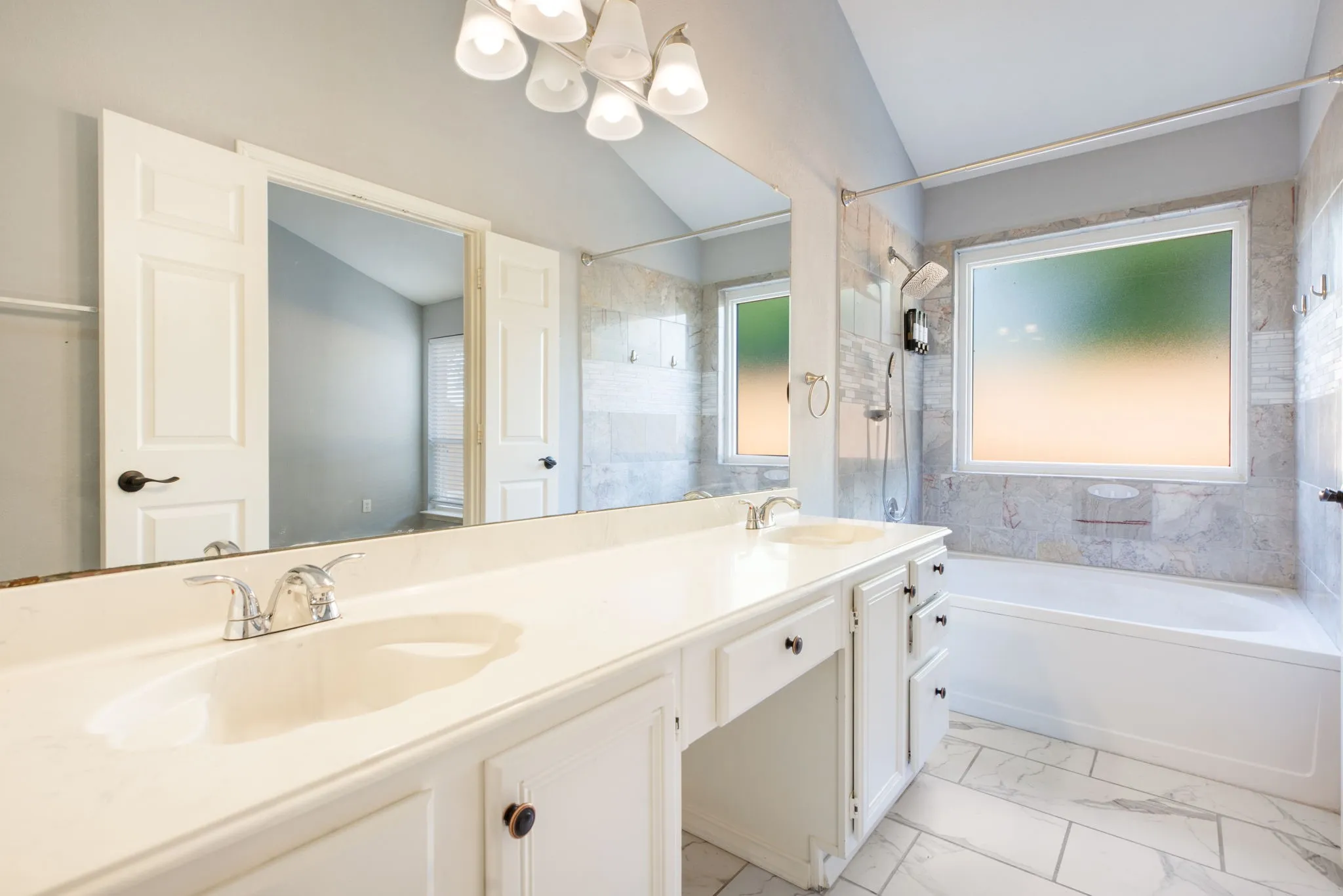 Double vanity with integrated sinks, white cabinetry, and polished chrome faucets