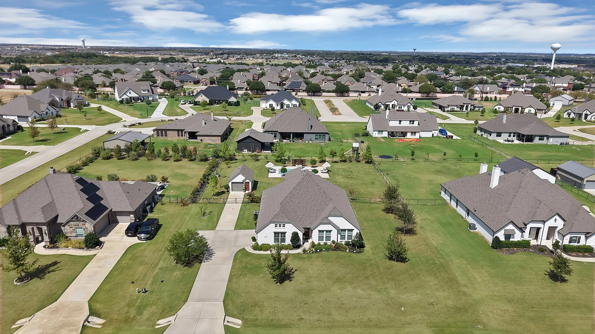 Expansive residential area featuring numerous single-family homes with pitched roofs, mature landscaping, and concrete driveways