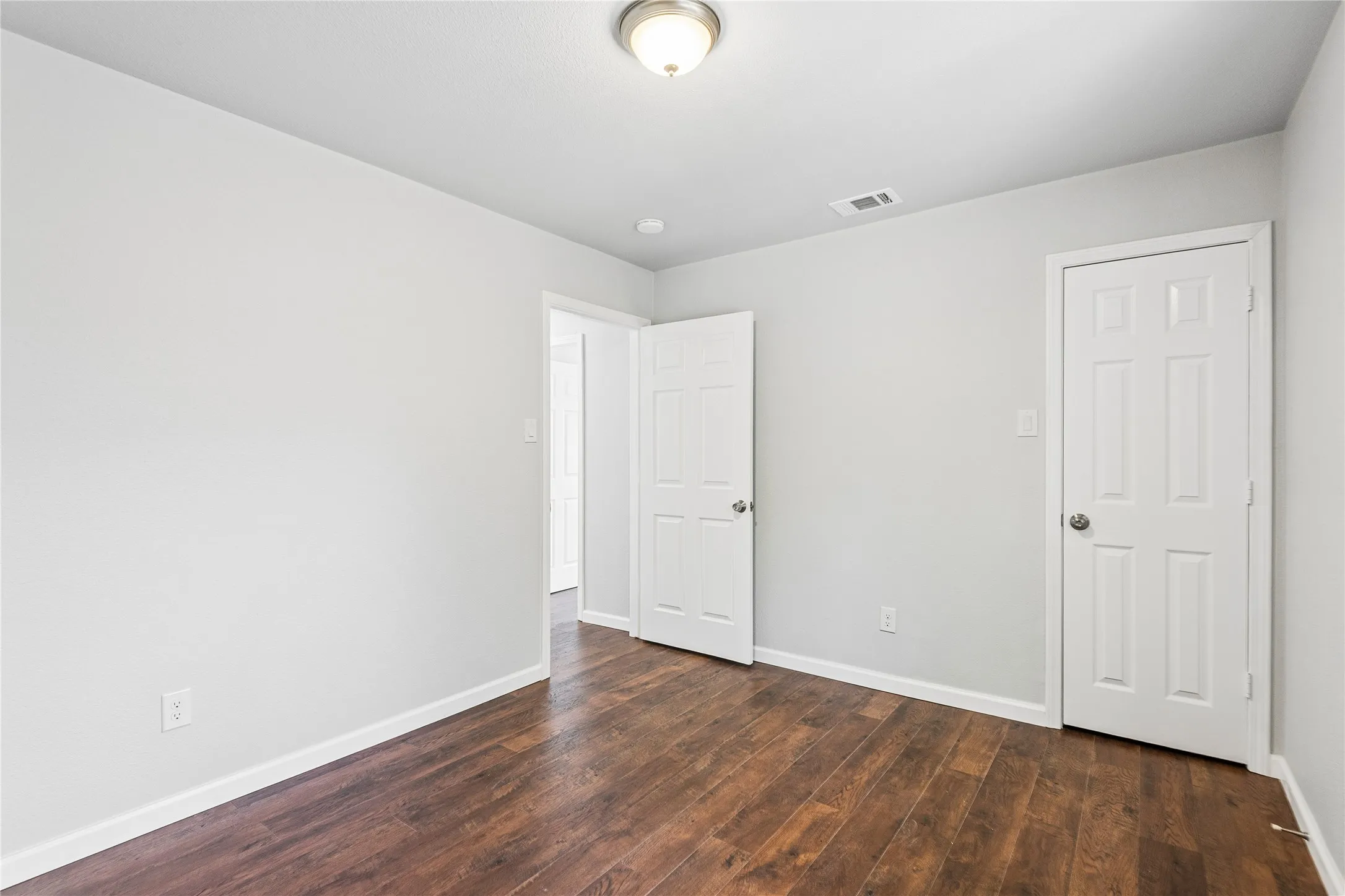 Wood-finish flooring, light gray wall paint, and white trim