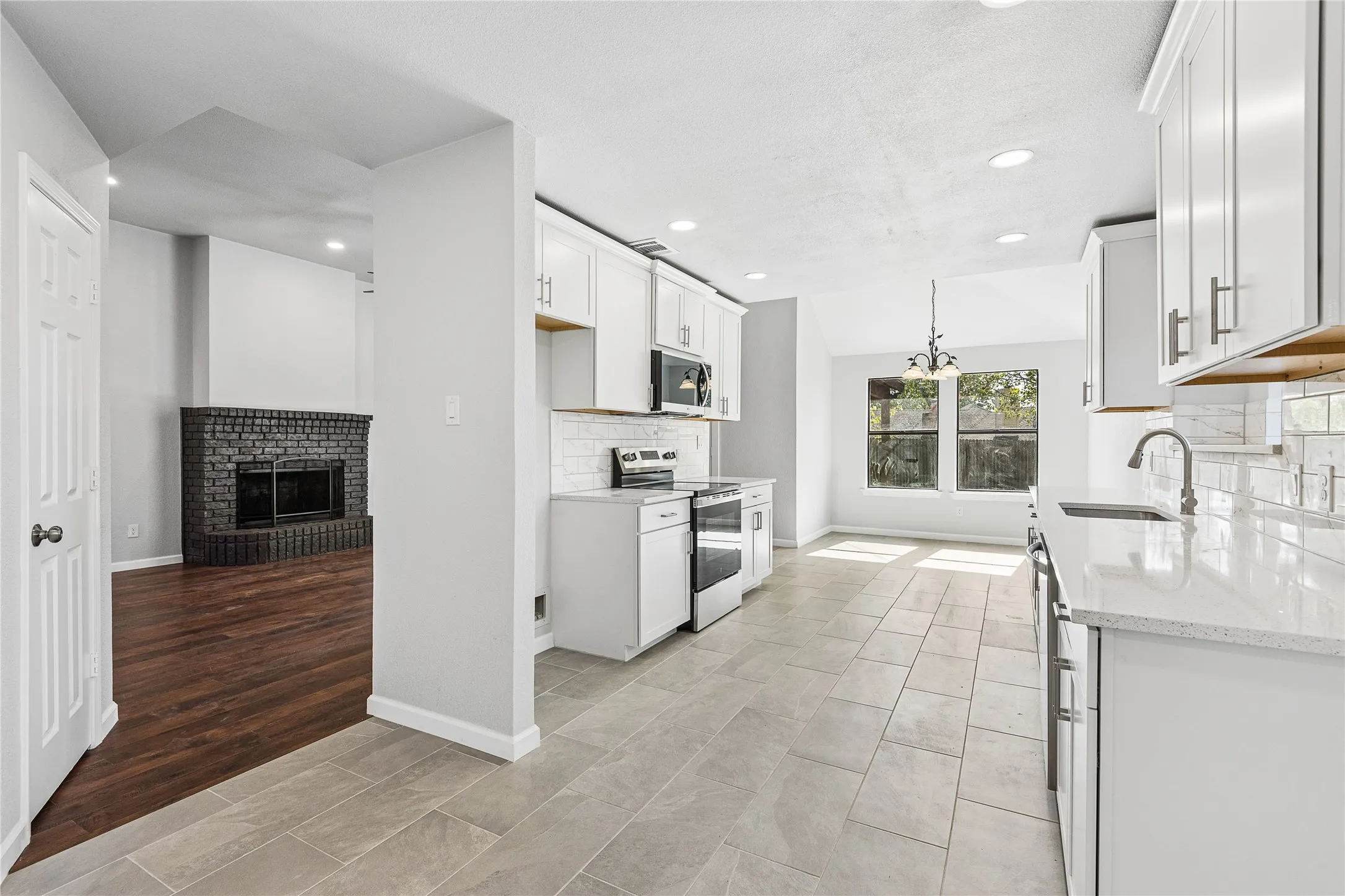 Spacious kitchen featuring white cabinetry, light-toned countertops, and tile flooring