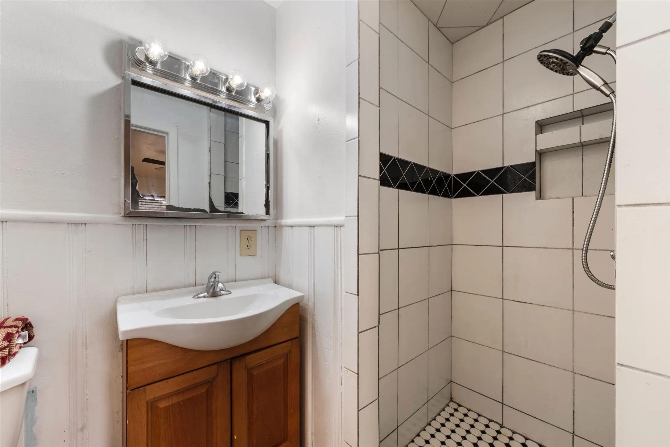 White subway tile shower with a built-in niche and black accent tile