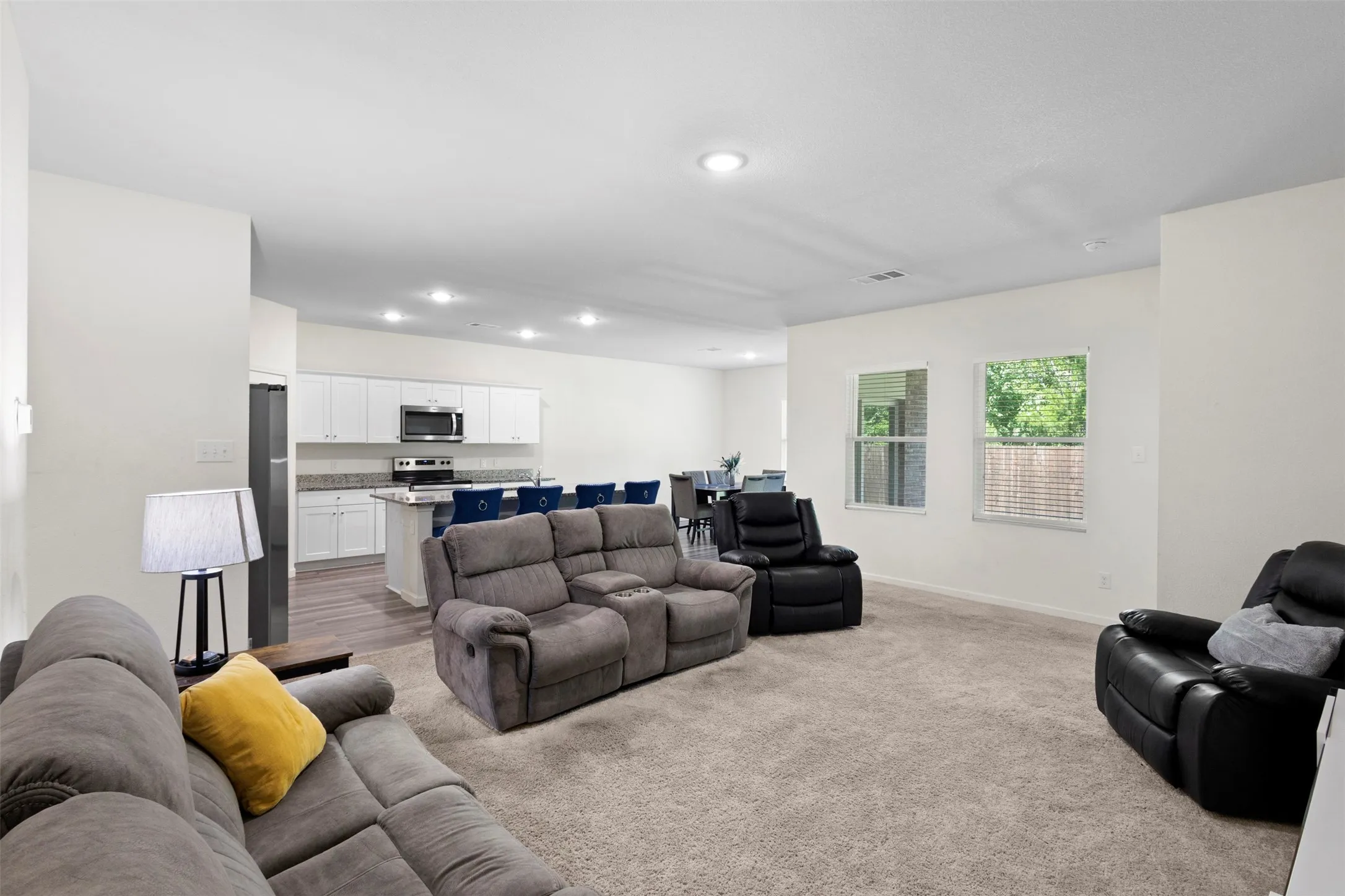 Open-concept living space featuring carpeted flooring and recessed lighting