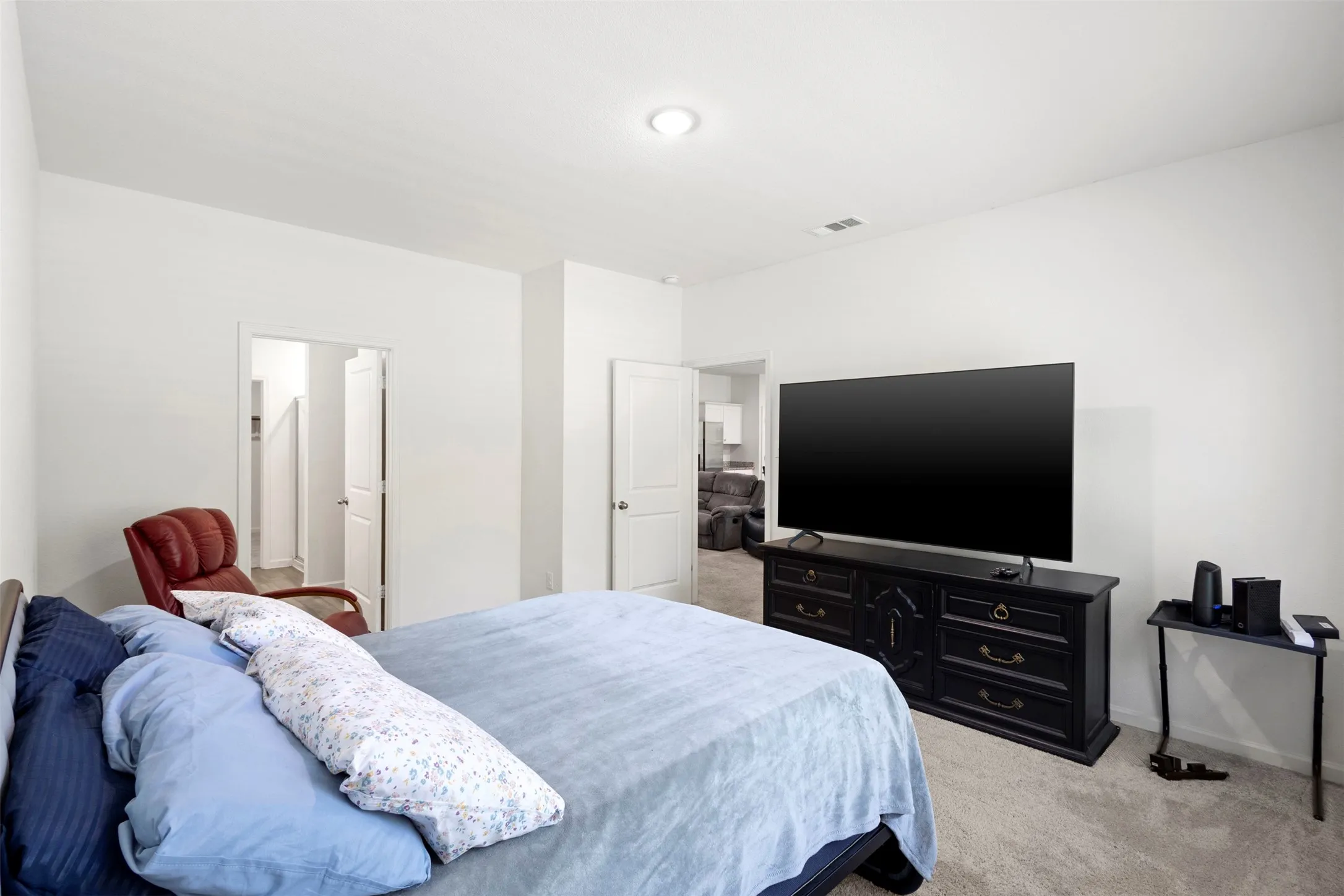 Carpeted flooring, white walls, and a ceiling-mounted light fixture