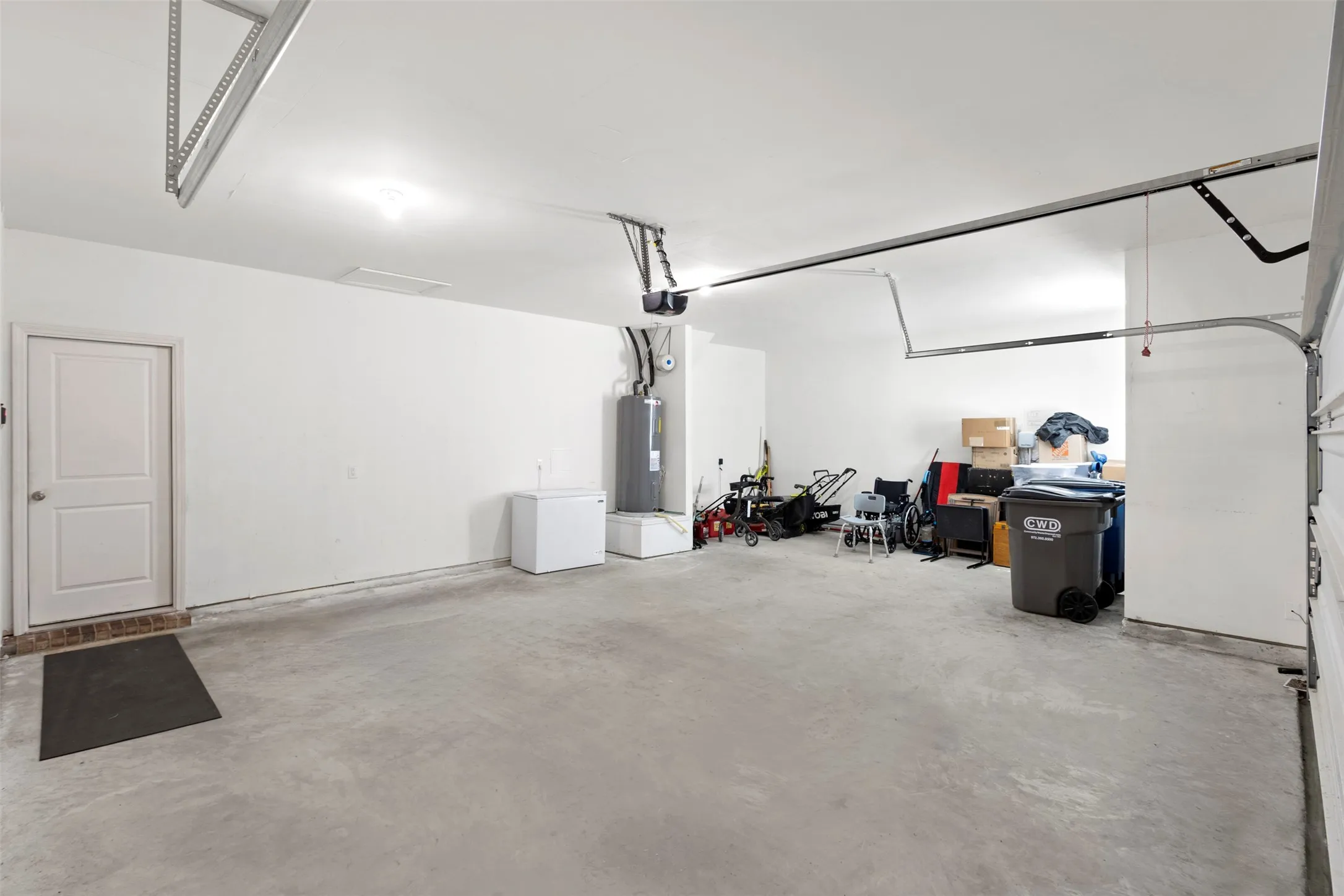 Expansive garage with concrete flooring, white painted walls, and an interior access door