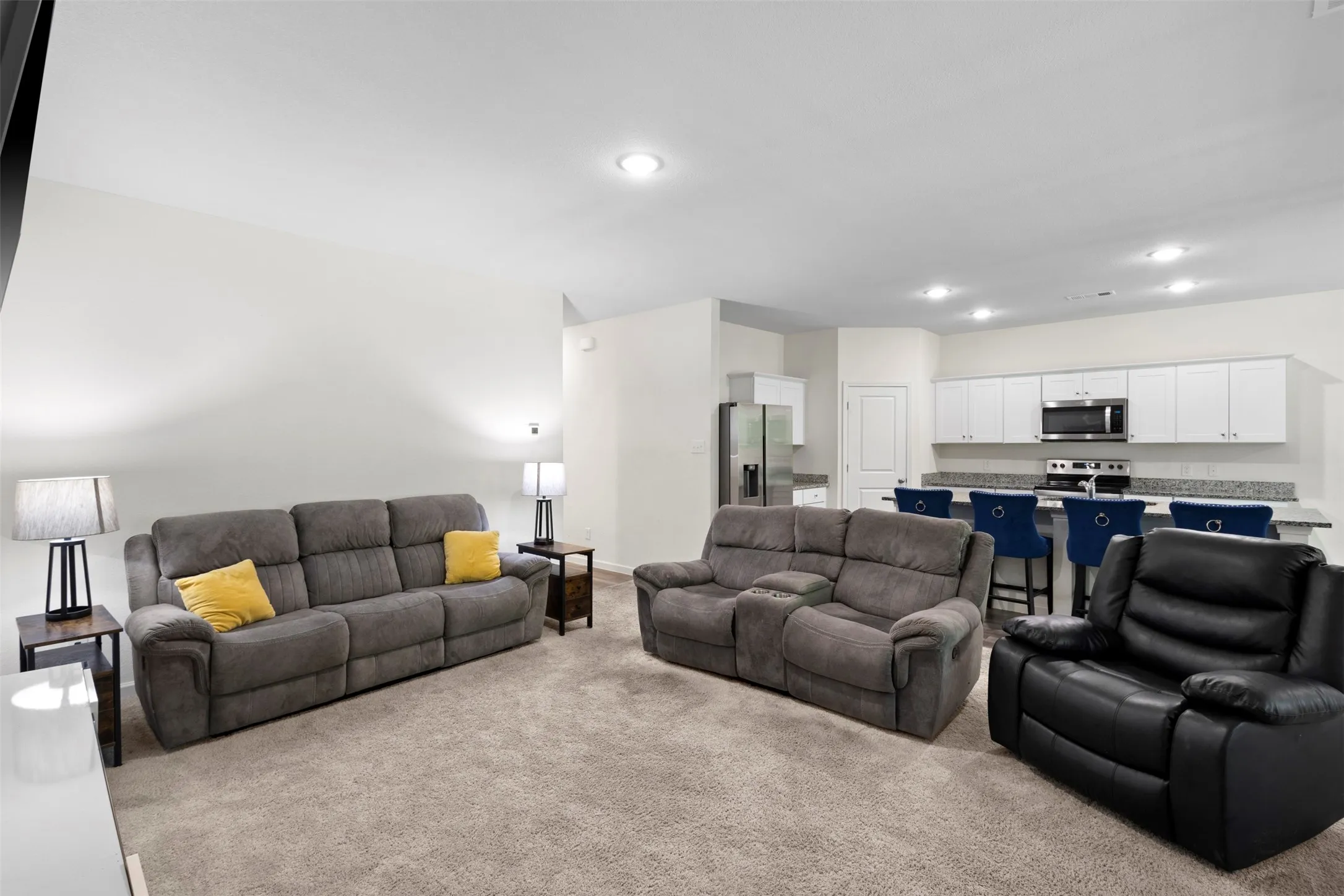 Open-concept living space featuring carpeted flooring and recessed lighting