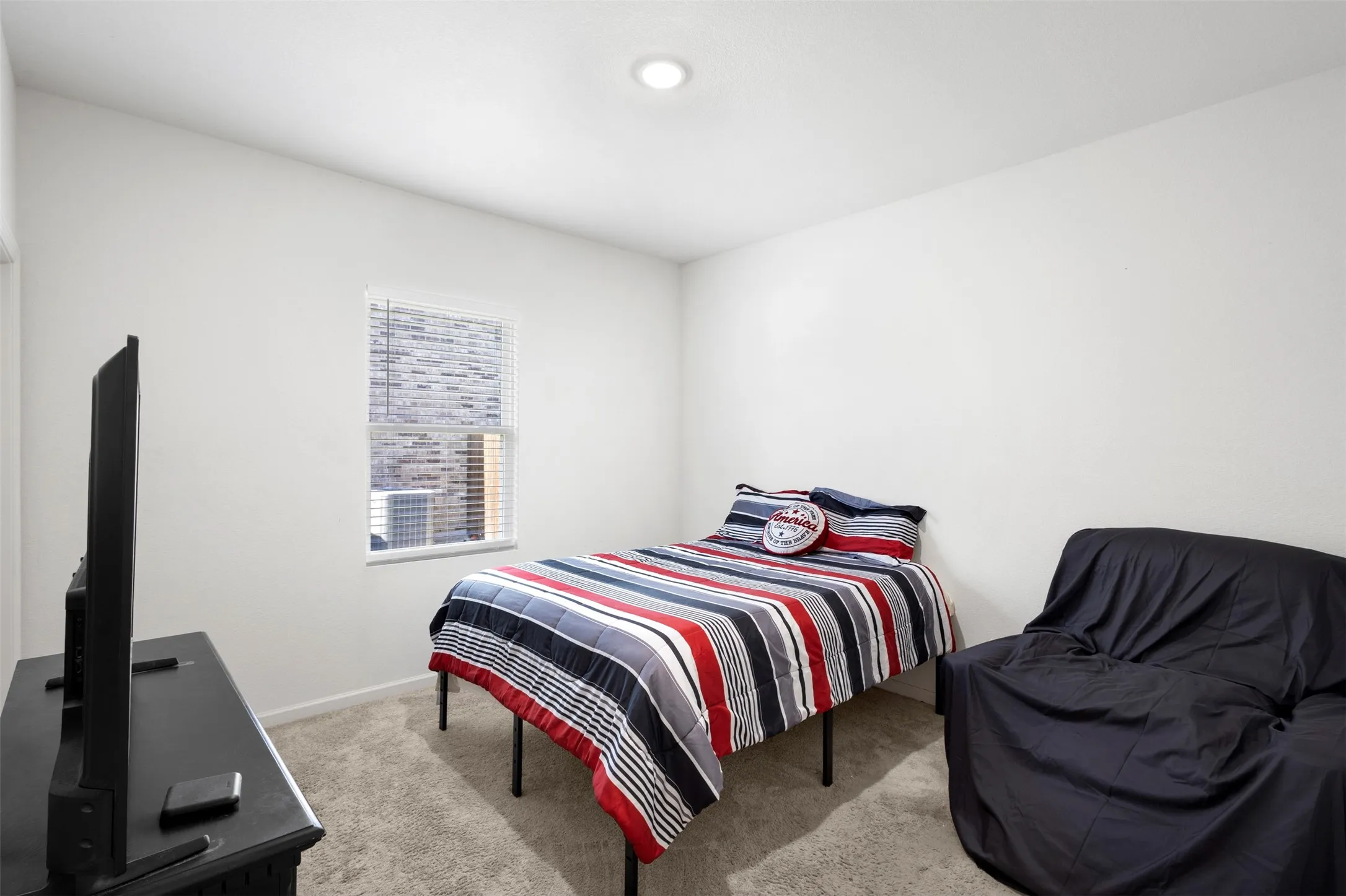 Recessed ceiling lighting, window with blinds, light-colored walls, and carpeted flooring