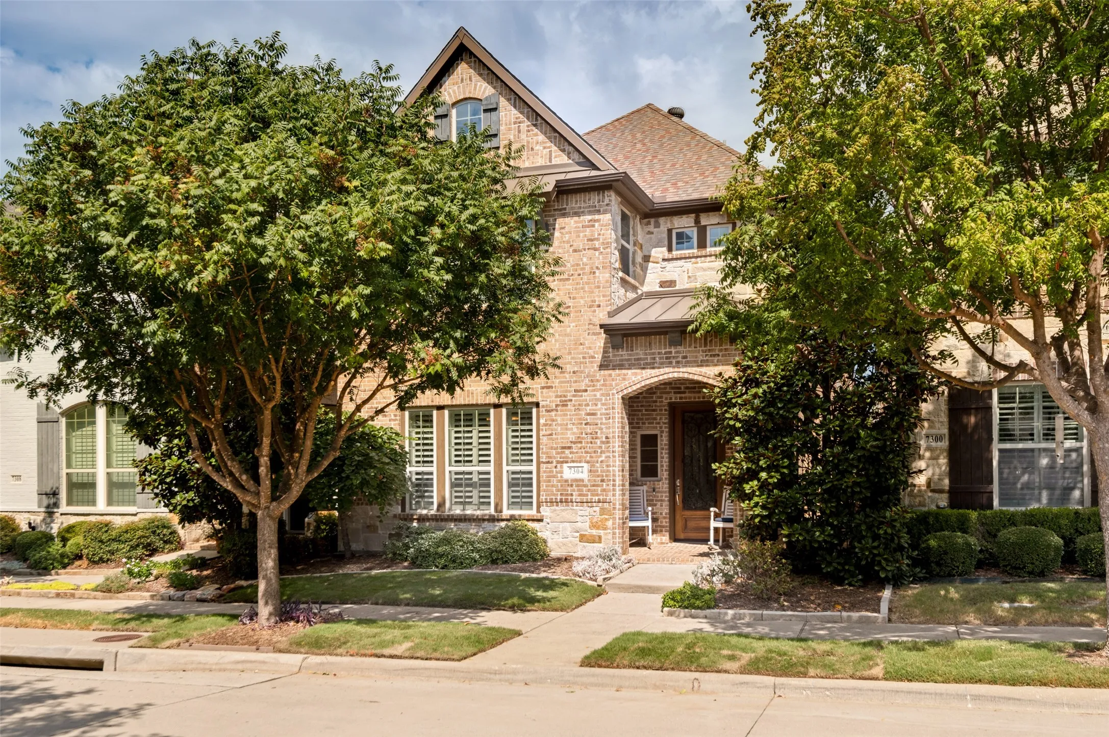 Beautiful stone & brick exterior framed by mature trees, fresh sod & inviting curb appeal in sought-after Spicewood at Craig Ranch.