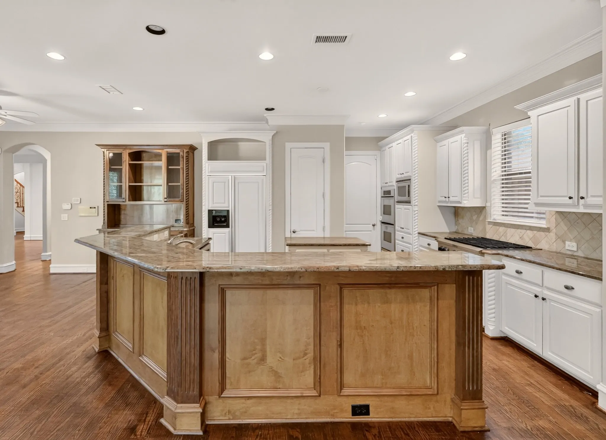 island kitchen, granite counters, double ovens, wood flooring and walk in pantry