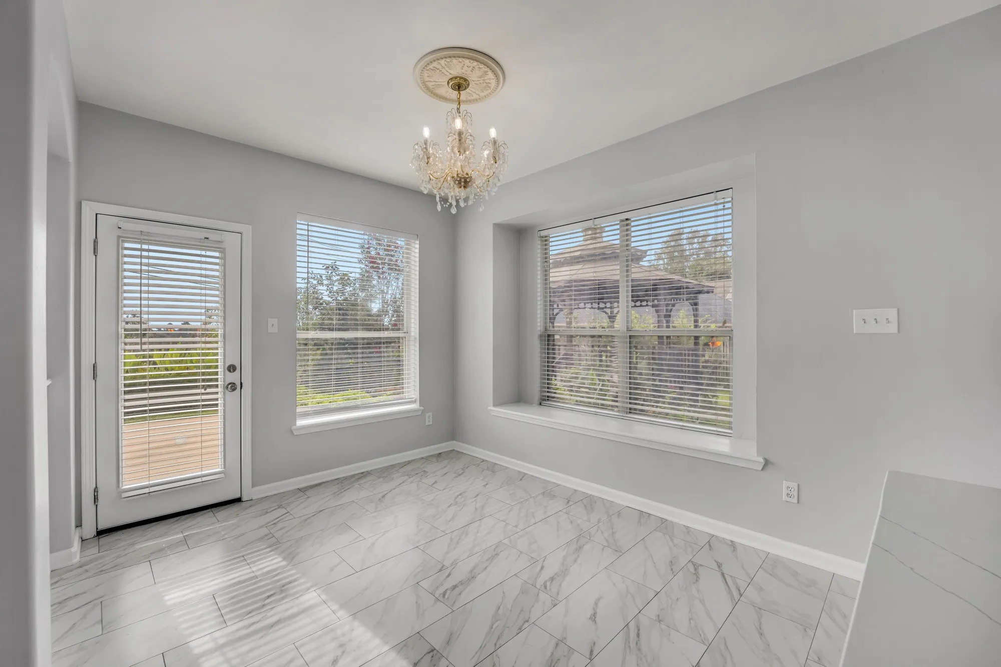 Recessed window seat, glass-paneled door, and large windows with horizontal blinds