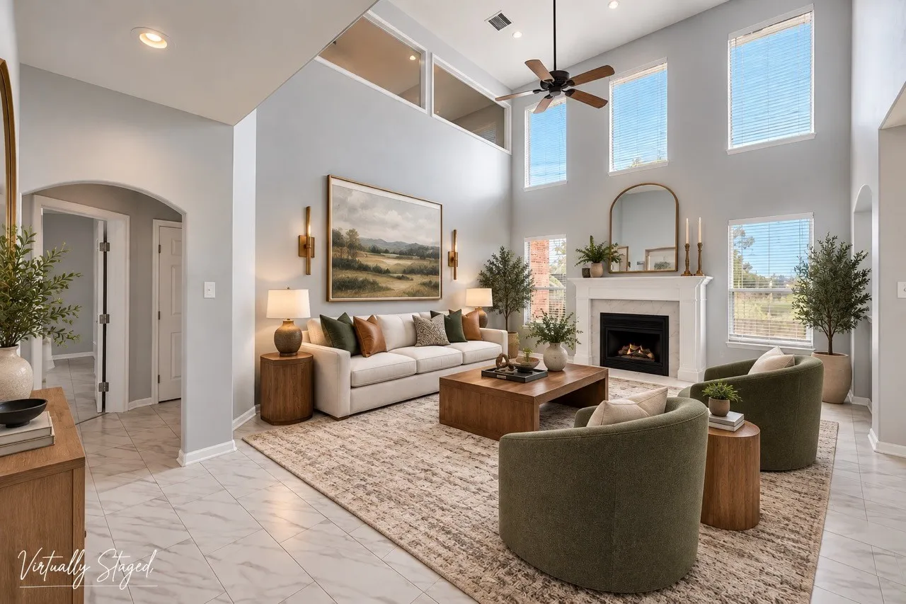 Two-story living area with high ceilings, a fireplace with a mantel, multiple windows, and a ceiling fan