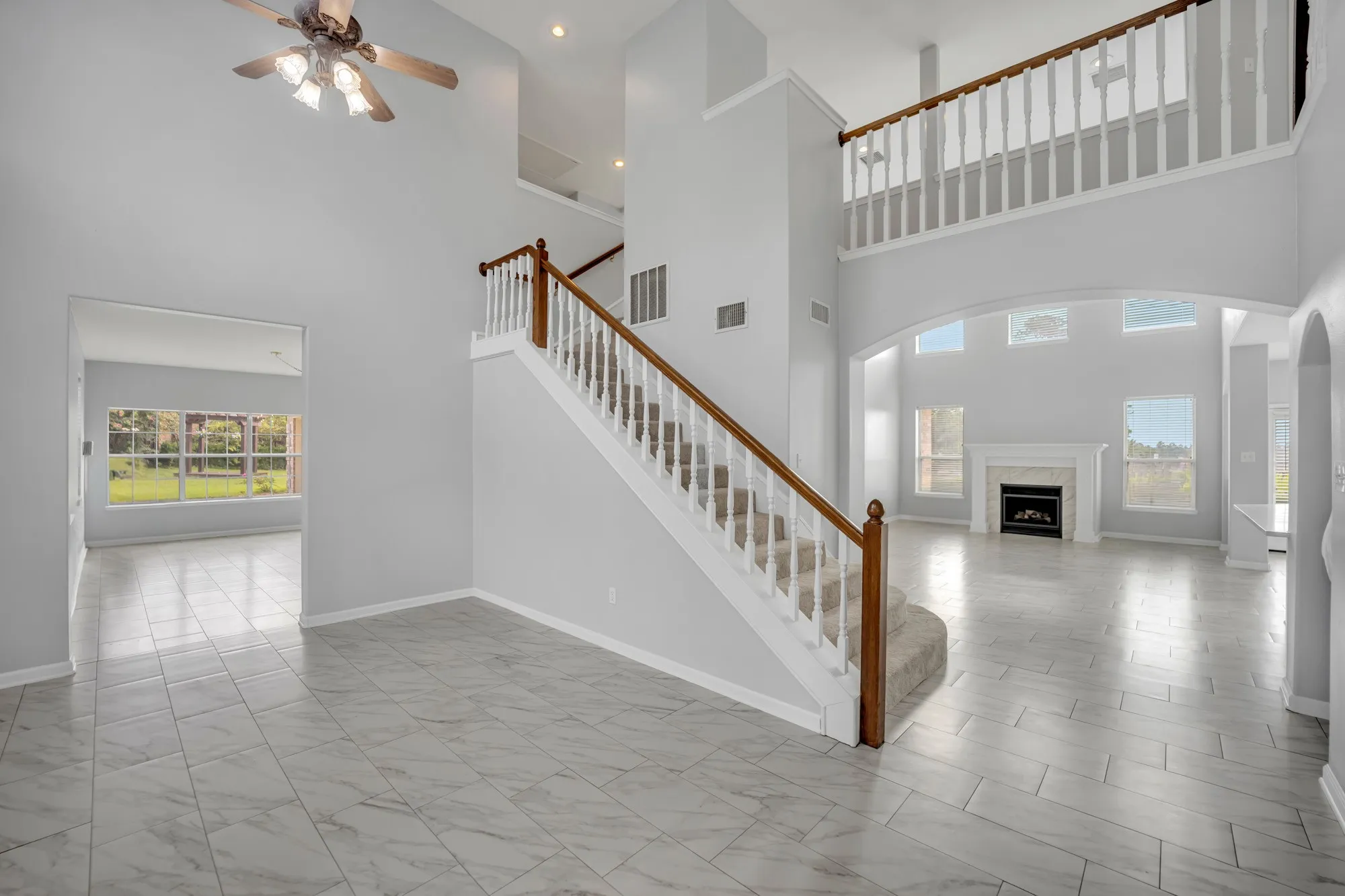 Two-story foyer with a wood-finish staircase and white balusters