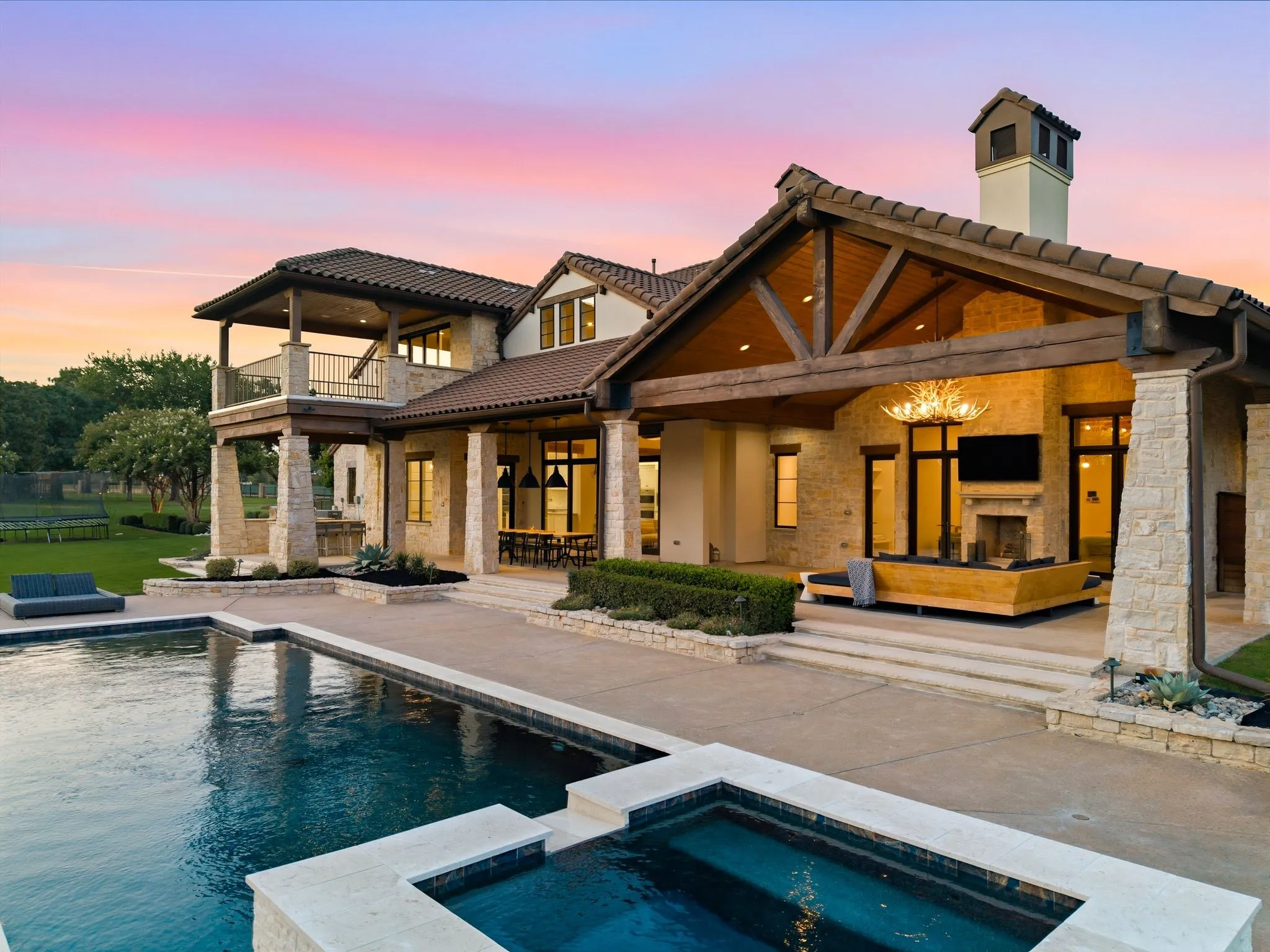 Twilight transforms the pool and outdoor living areas into a stunning retreat.