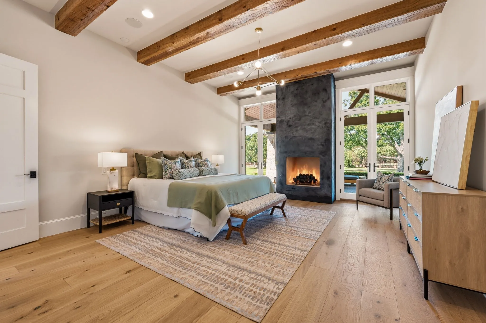 A serene primary retreat with a fireplace and outside views.