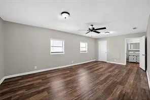 Wood-finish flooring throughout, ceiling fan, and two windows providing natural light