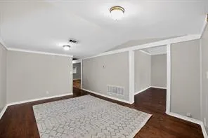 Rich wood-finish flooring, light gray wall paint, and white trim accents