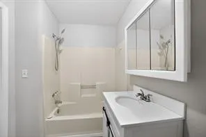 White vanity with integrated sink, chrome-finish faucet, and coordinating medicine cabinet