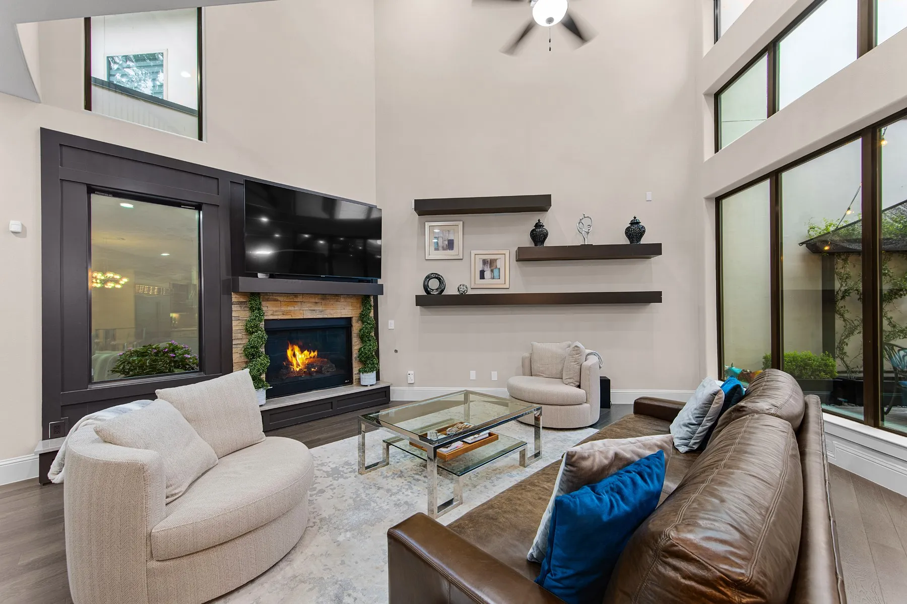 Two-story living area with large windows and cozy fireplace