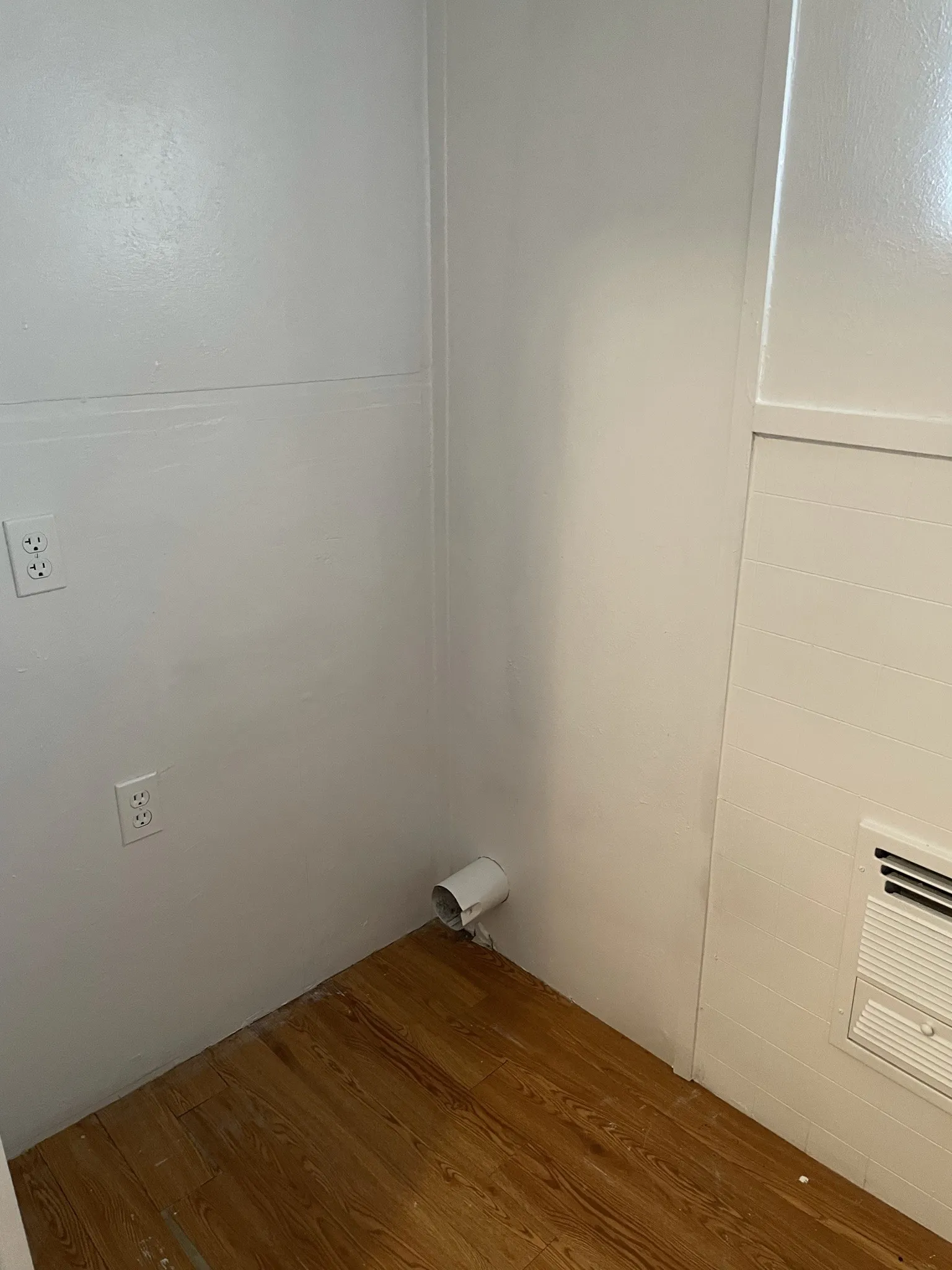 Laundry room with wood finished floors