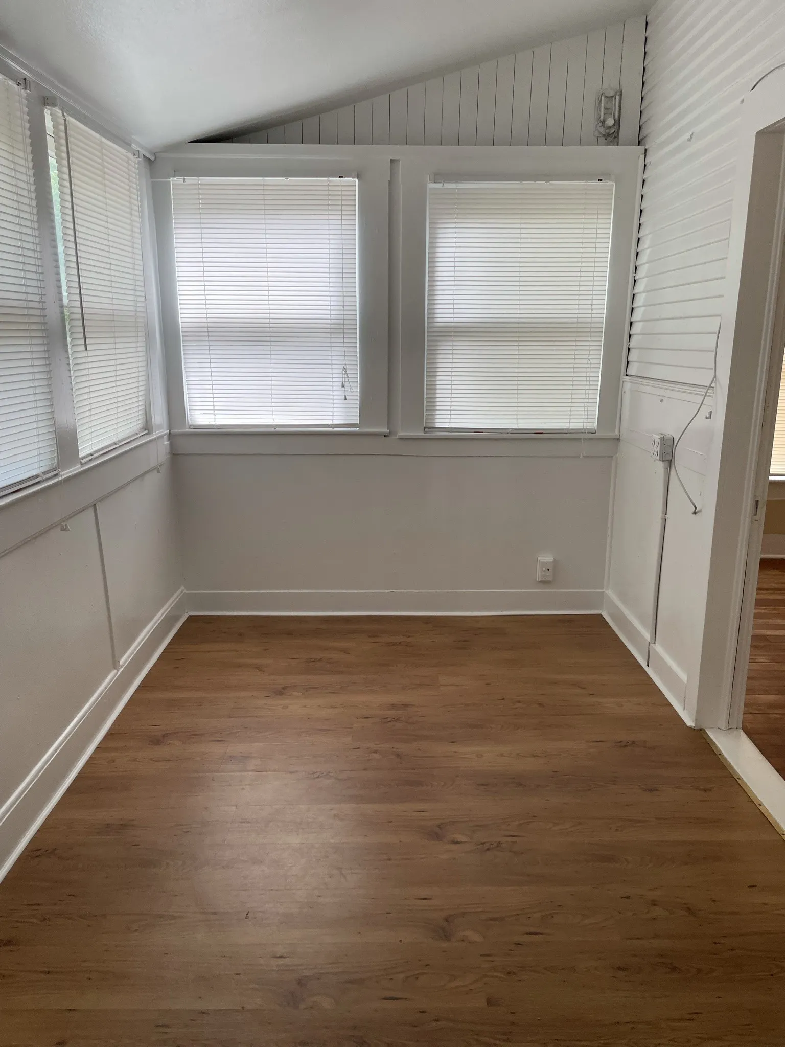 Unfurnished room featuring lofted ceiling and dark wood-style flooring
