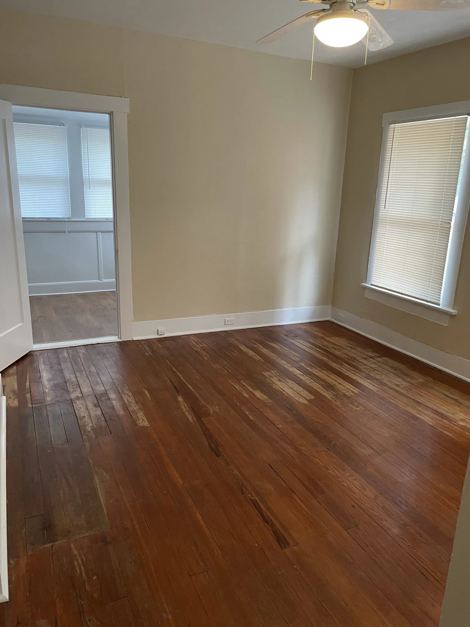 Spare room featuring dark wood-type flooring and a ceiling fan
