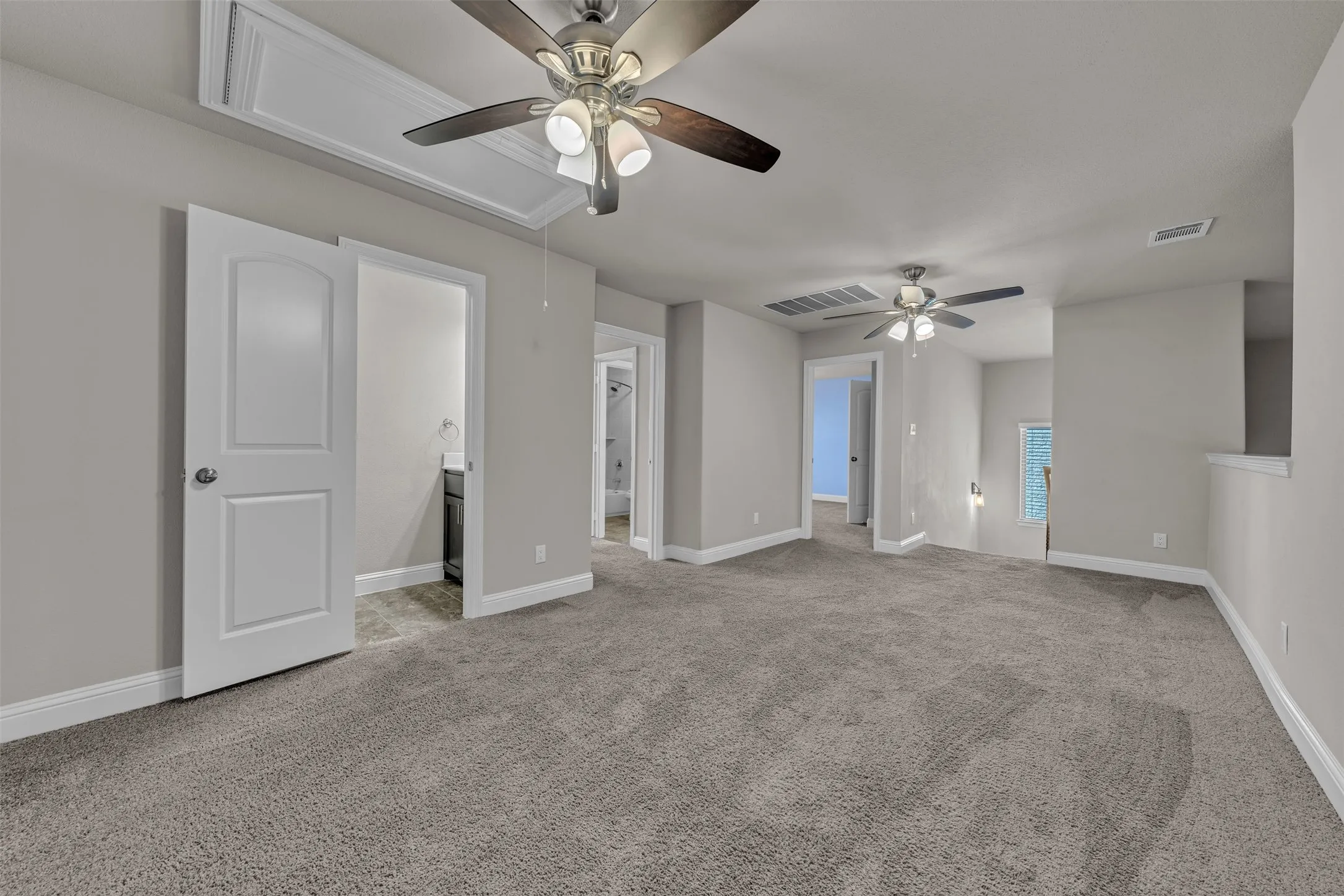 Plush carpeting throughout, multiple ceiling fans with integrated lighting, and neutral wall finishes