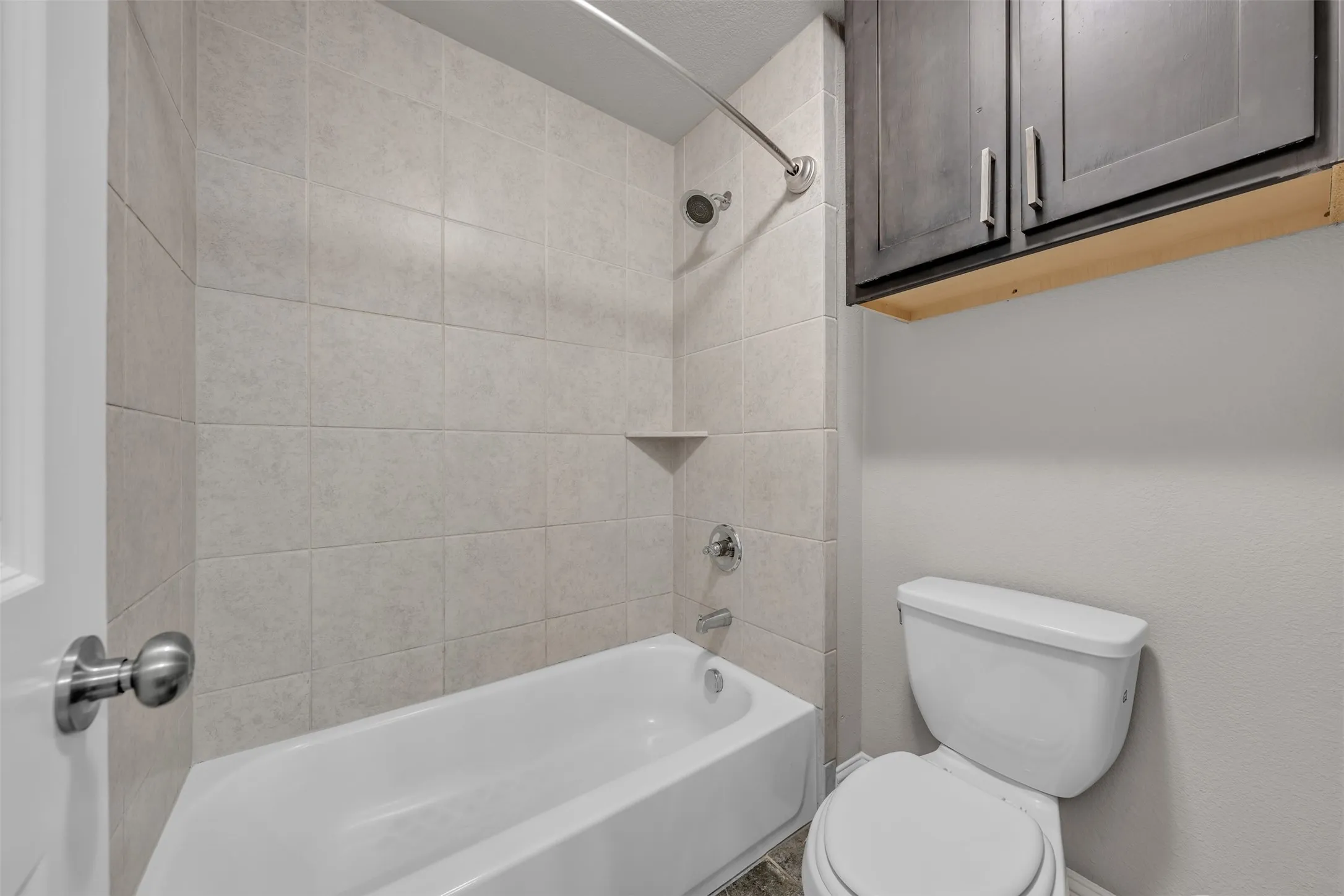 Bathtub with subway tile surround, integrated shower niche, and chrome fixtures