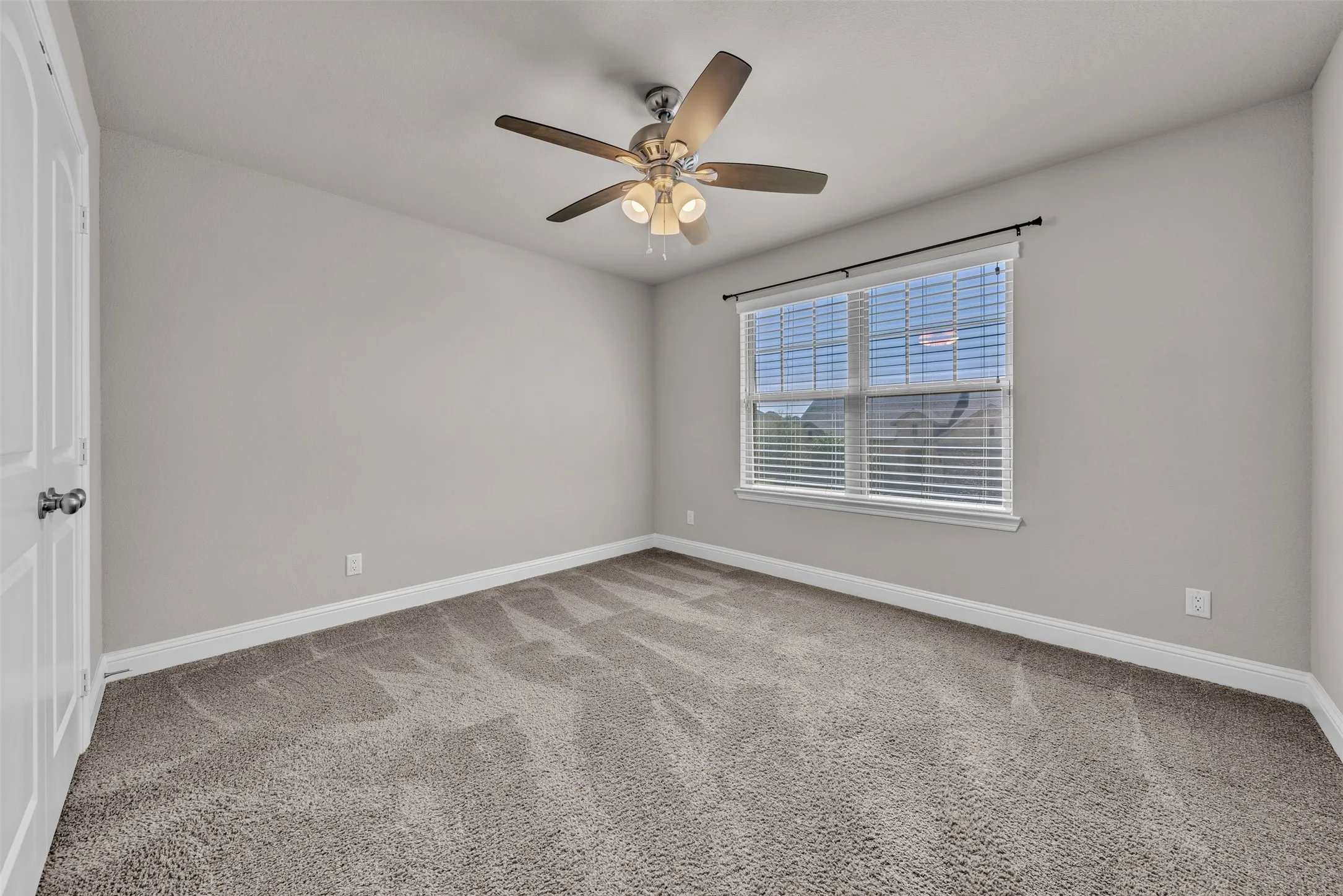 Light gray wall finish with a window featuring white blinds