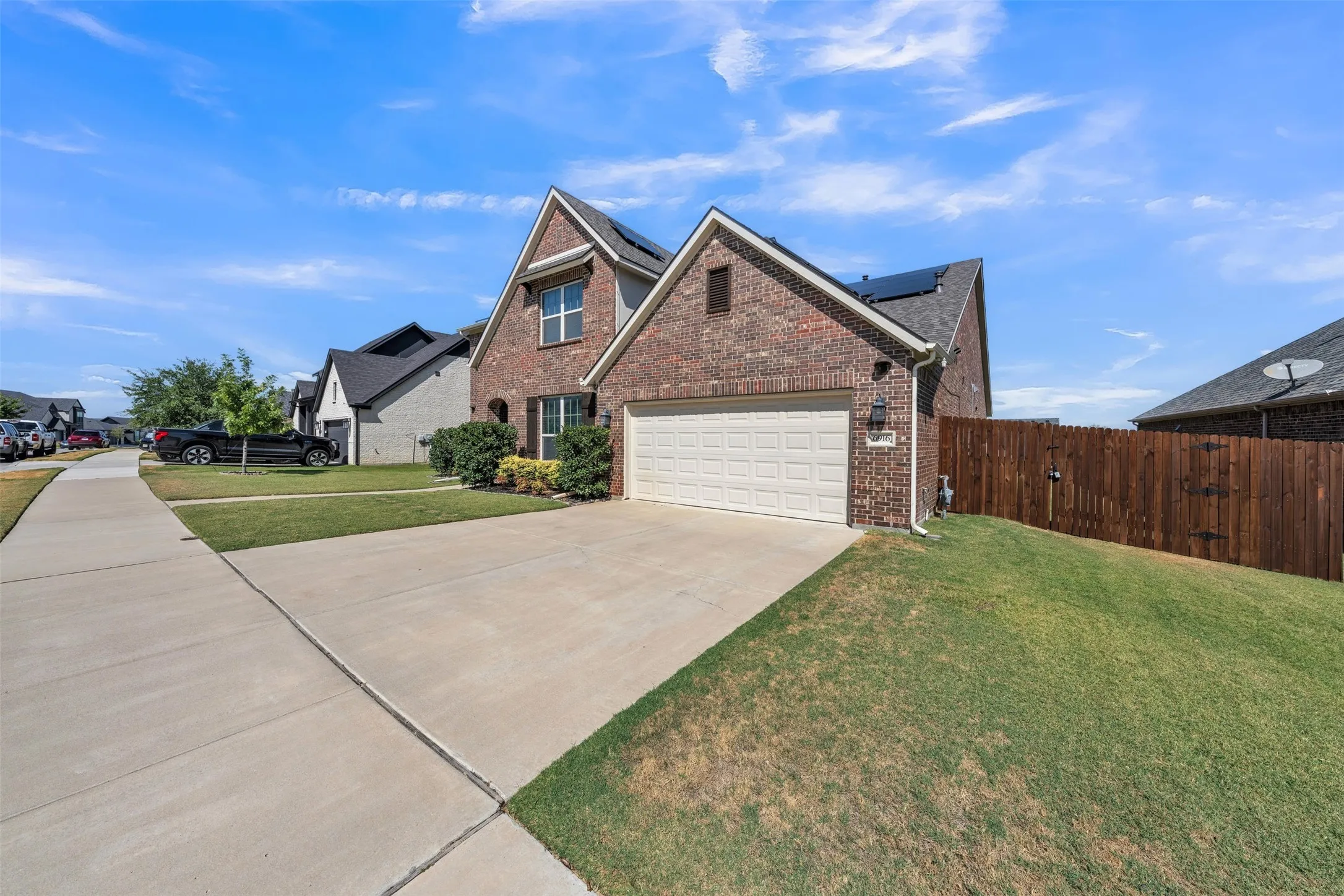 Brick exterior with a gabled roofline, attached garage, and a concrete driveway