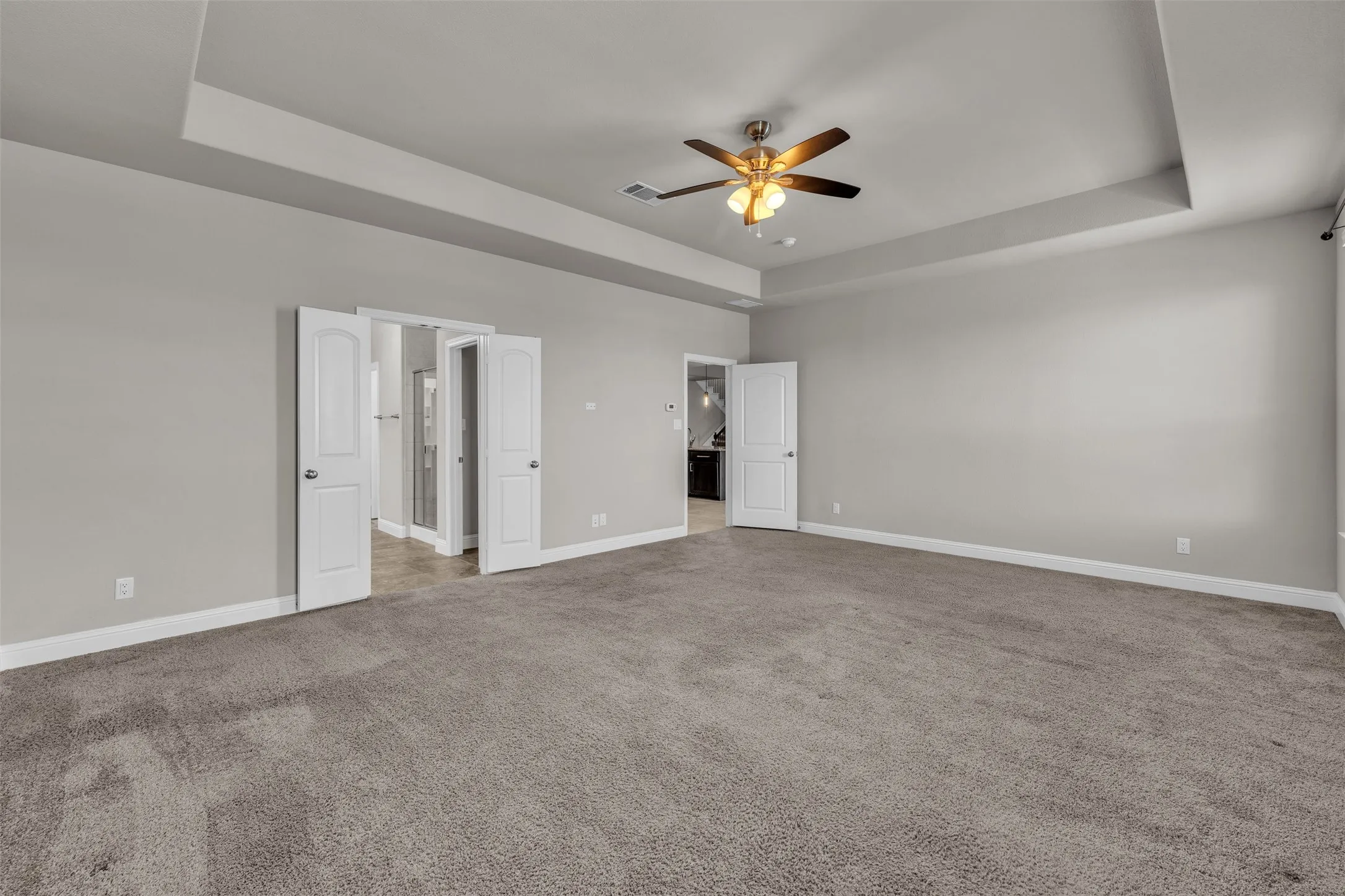 Recessed ceiling with ceiling fan, gray wall paint, and gray carpet flooring