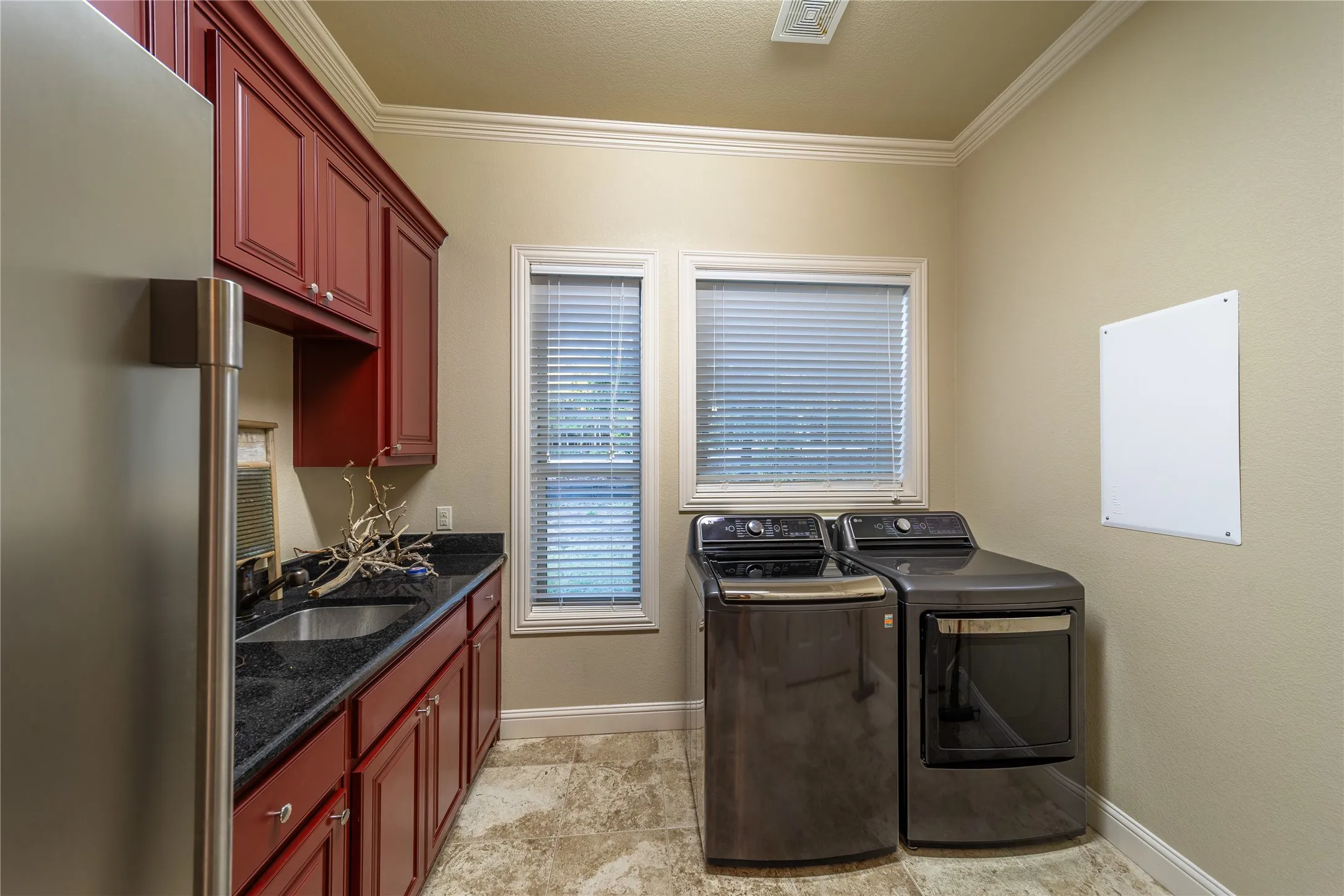 The laundry room is located off of the kitchen and features a standalone sink and room for an extra freezer.