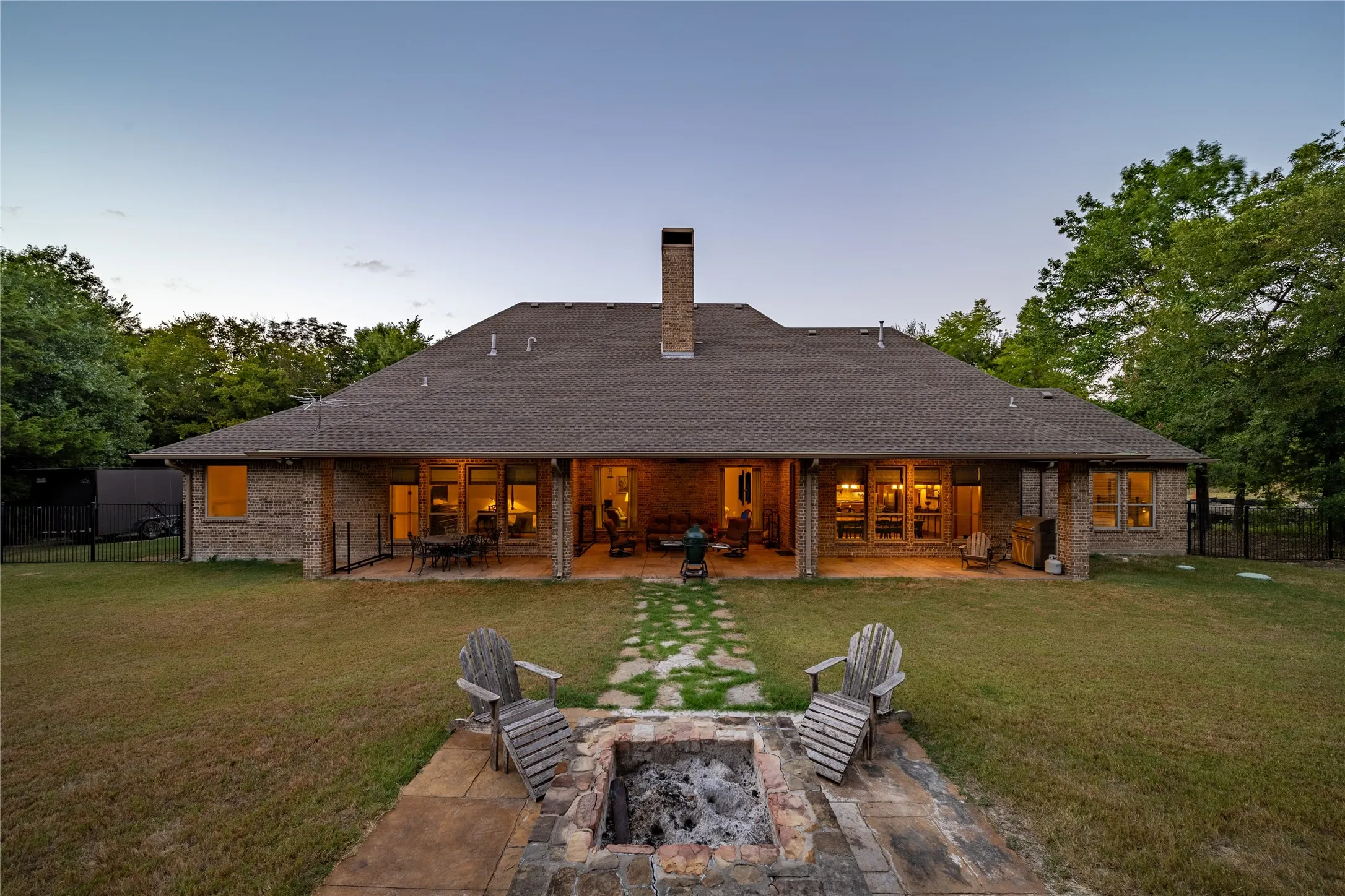 The back patio connects to the stone firepit that is in front of the stone retaining wall.